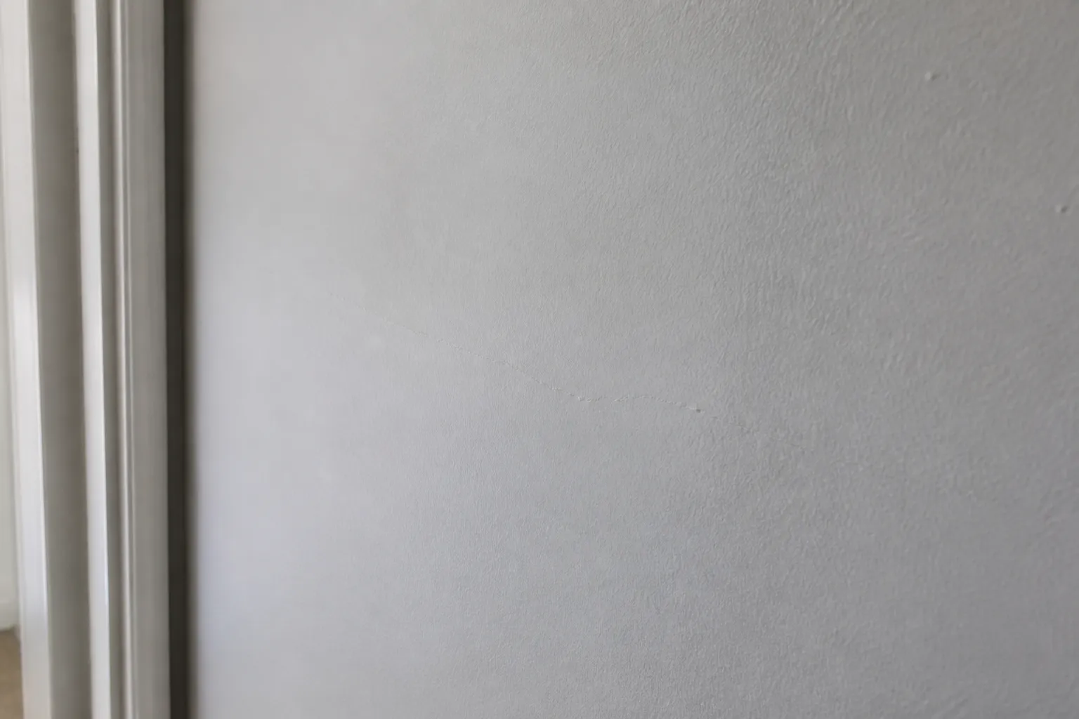 Mur fraîchement repeint masquant une fissure