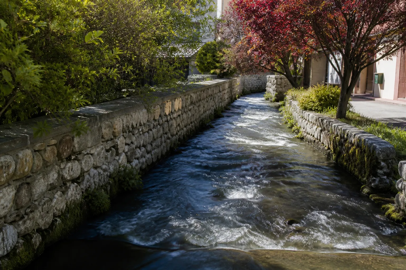 Petit torrent canalisé entre des murets en pierre en bordure de ville