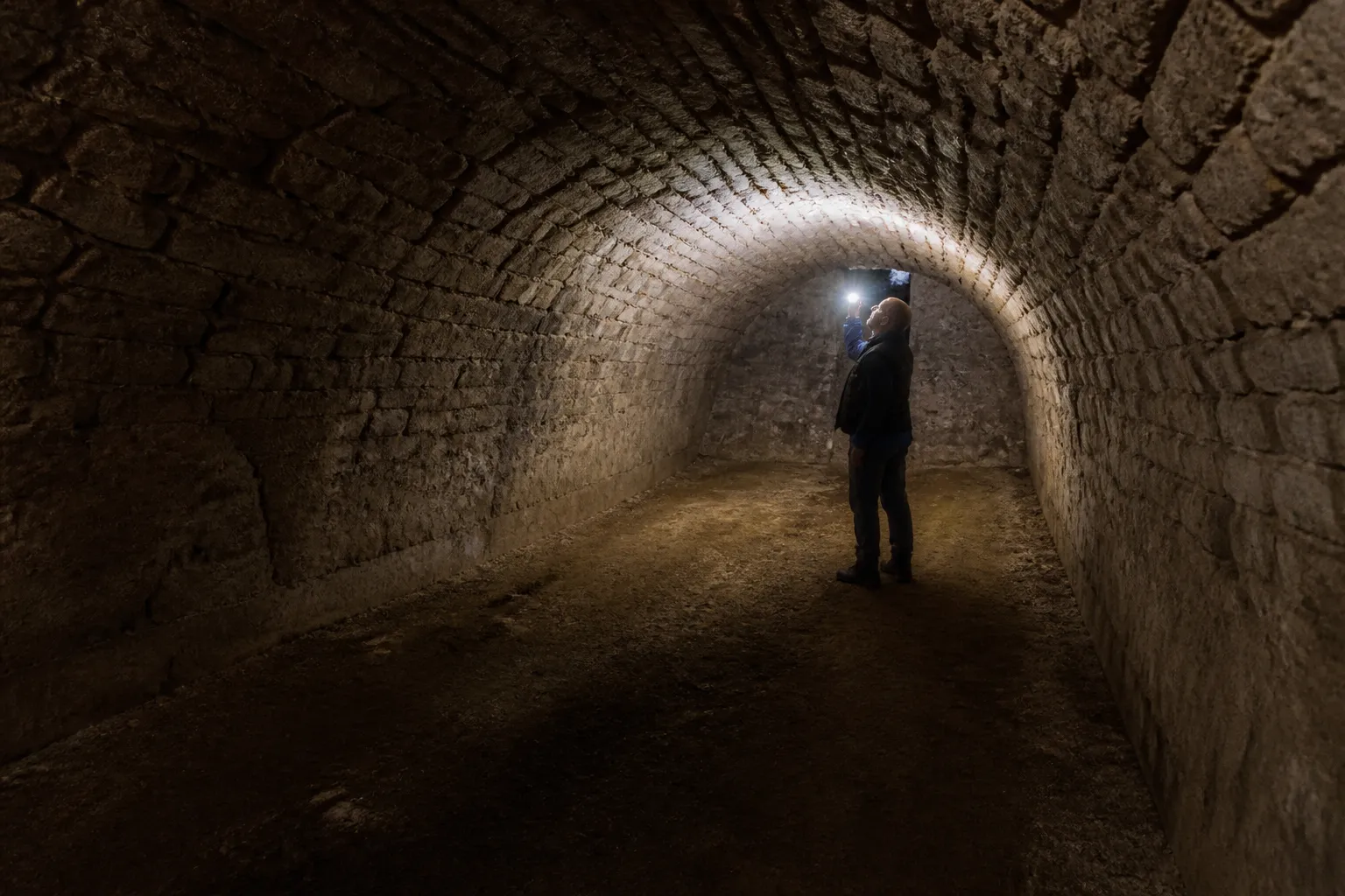 Cave voûtée en pierre inspectée à la lampe lors d’une expertise