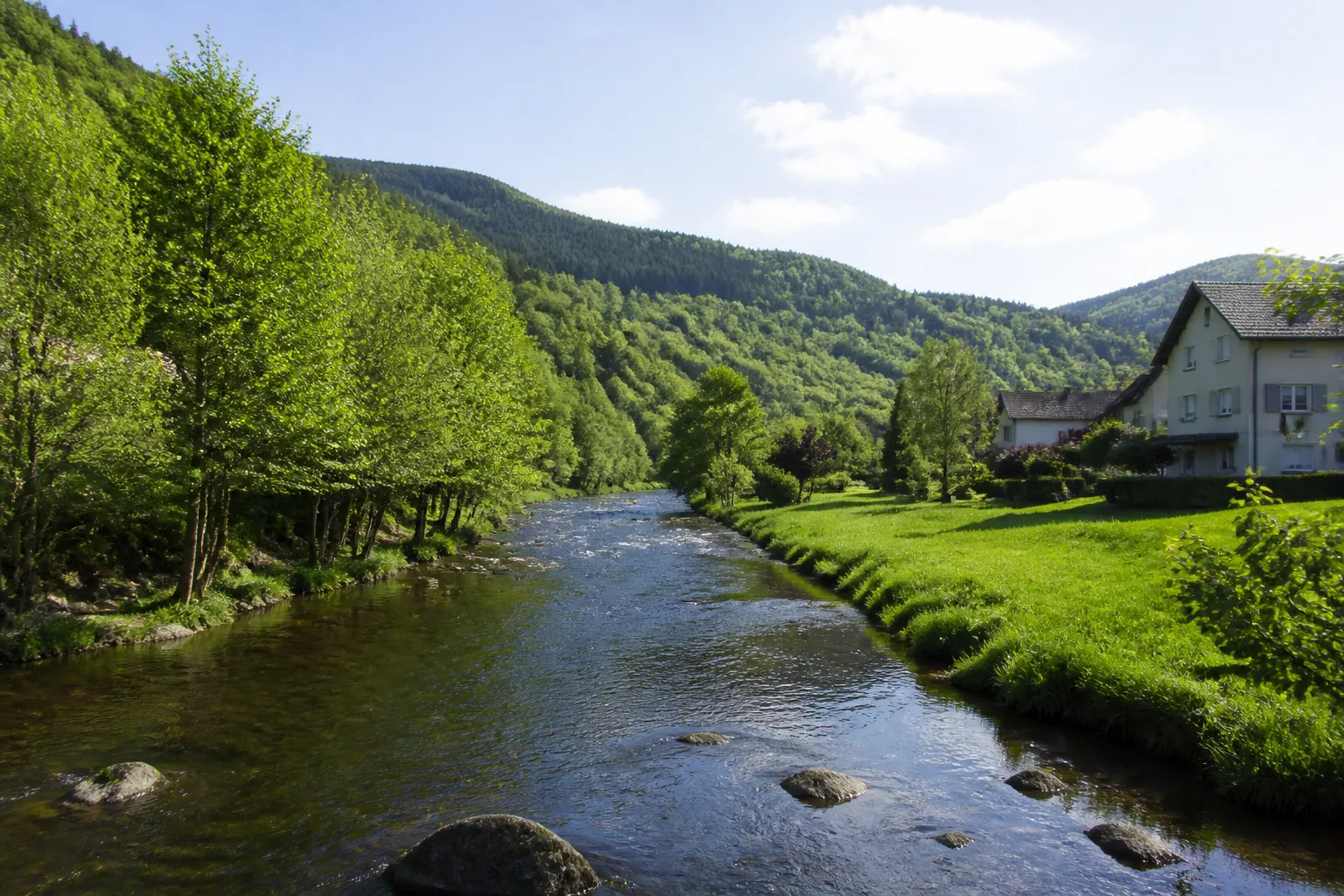 Petite rivière en fond de vallée près de maisons