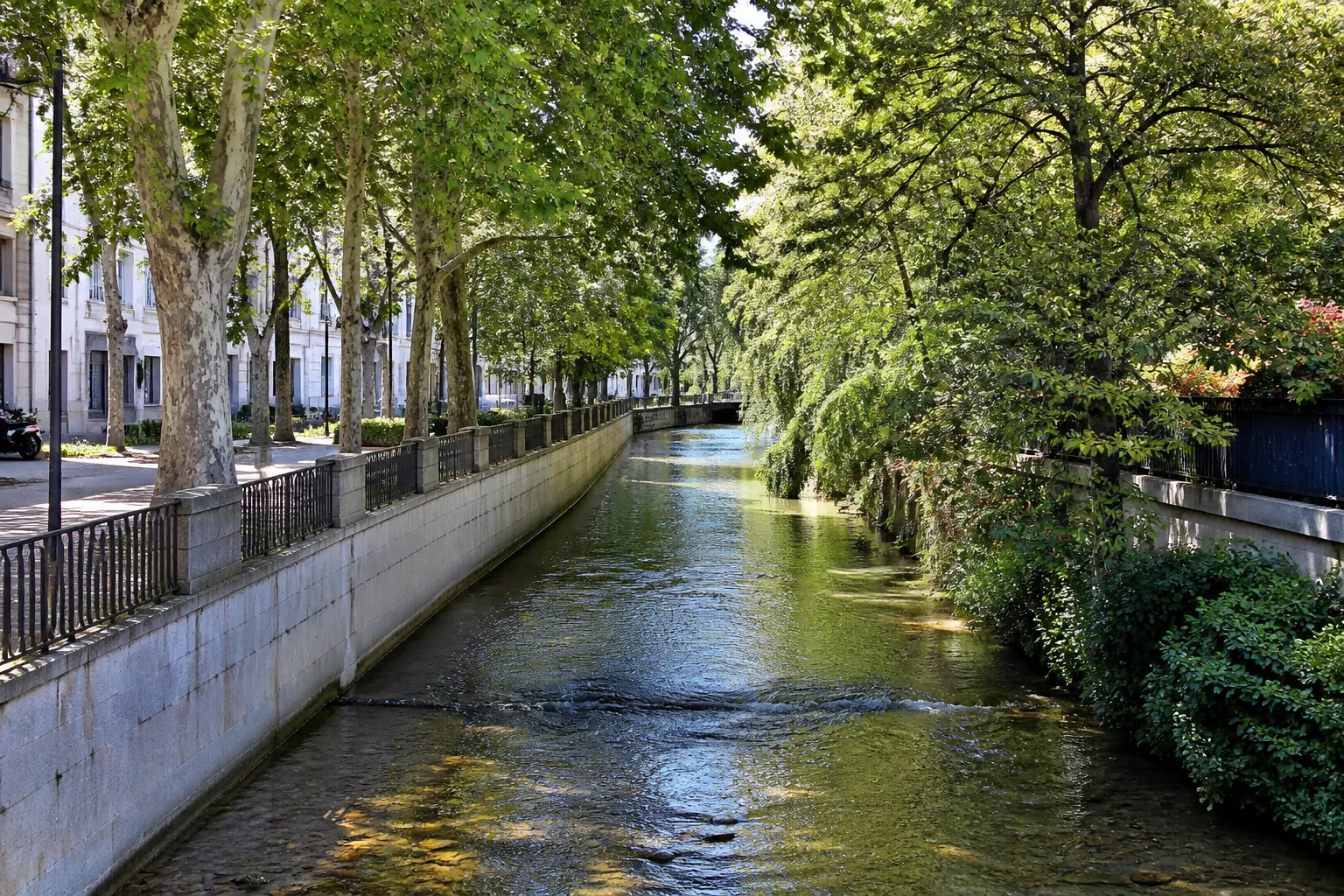 Petite rivière canalisée longée d’une promenade en ville