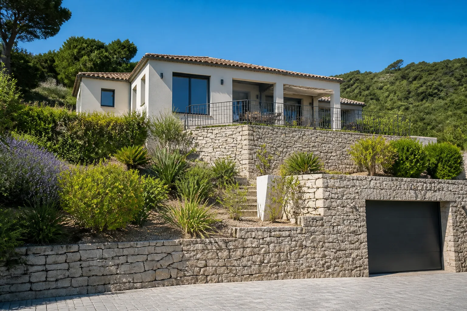 Maison sur un terrain en pente avec mur de soutènement en pierre