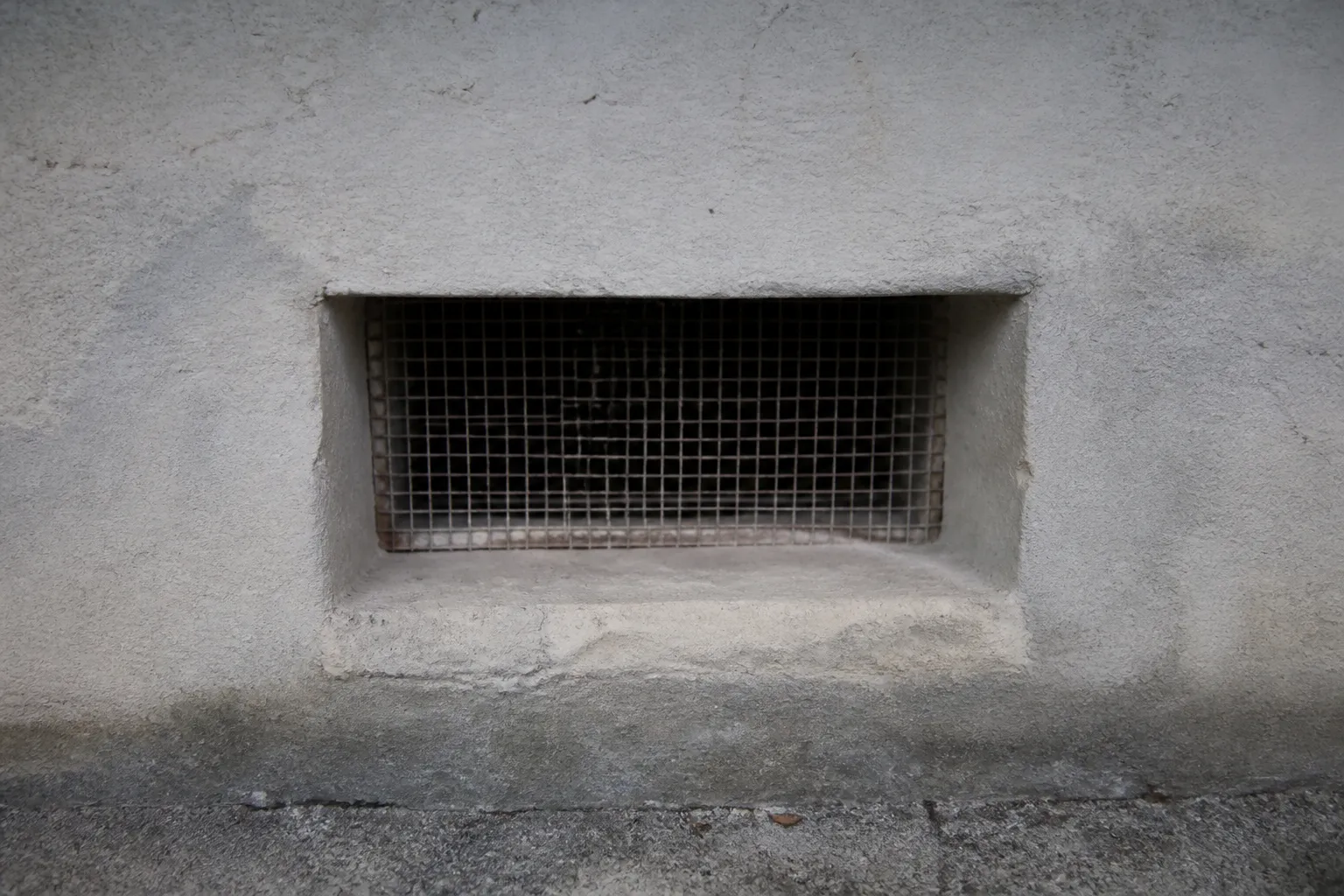 Bouche de ventilation dans un mur de sous-sol
