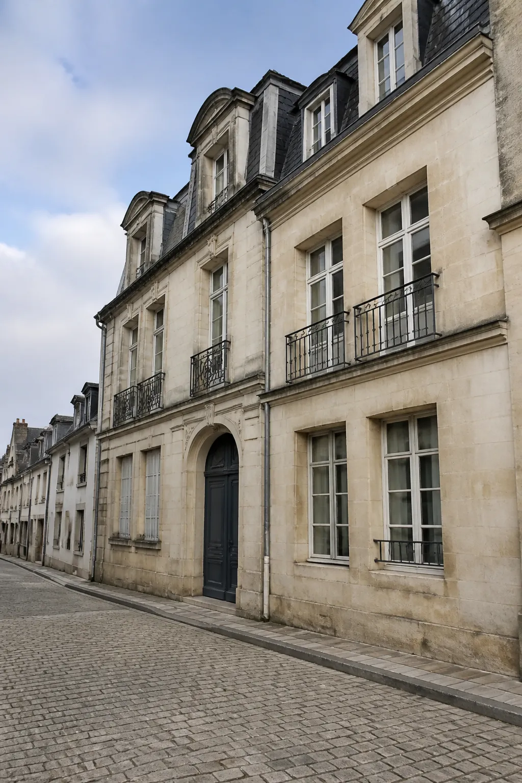 Immeuble ancien en pierre calcaire dans une rue de ville moyenne