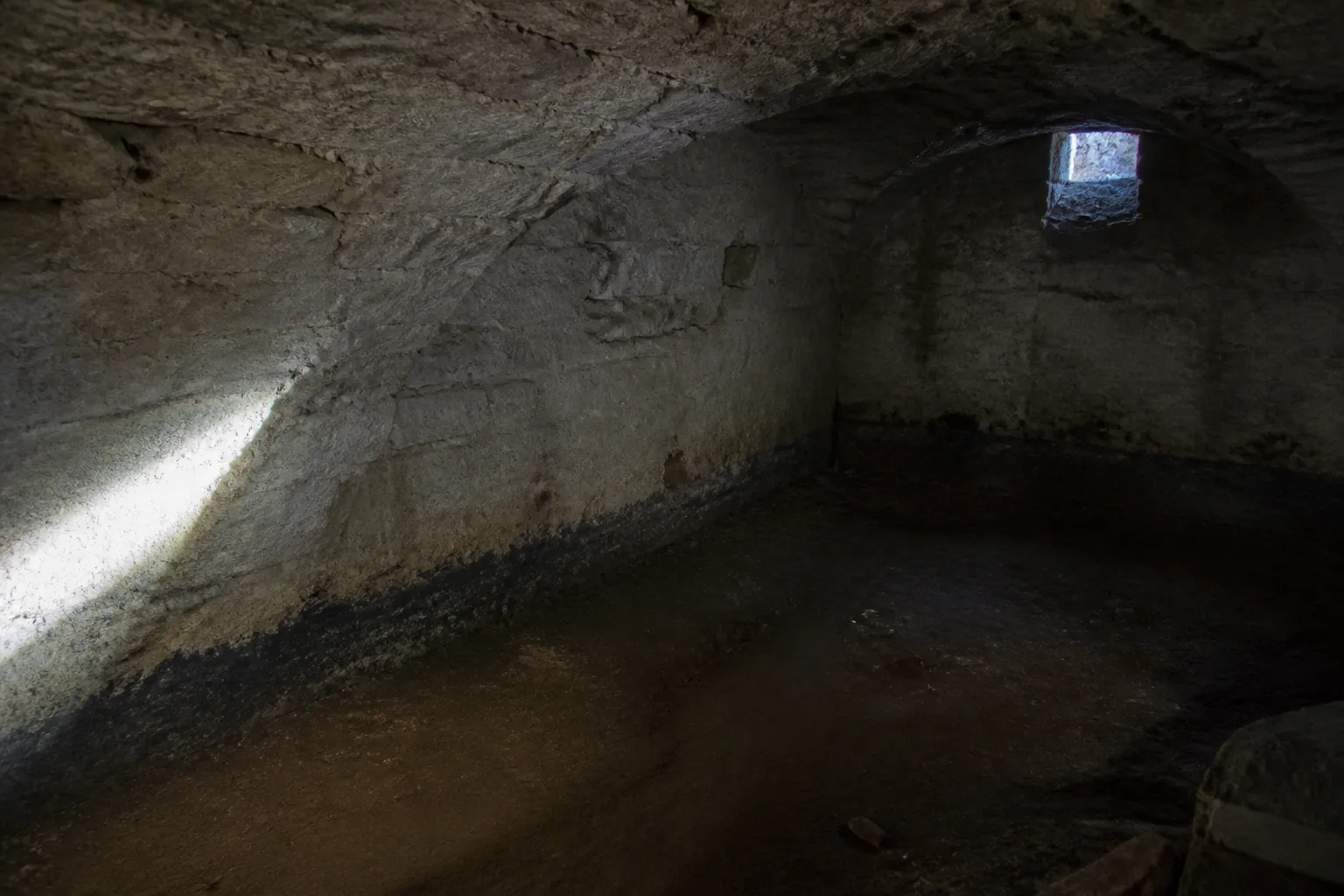 Cave voûtée d’un immeuble ancien inspectée à la lampe