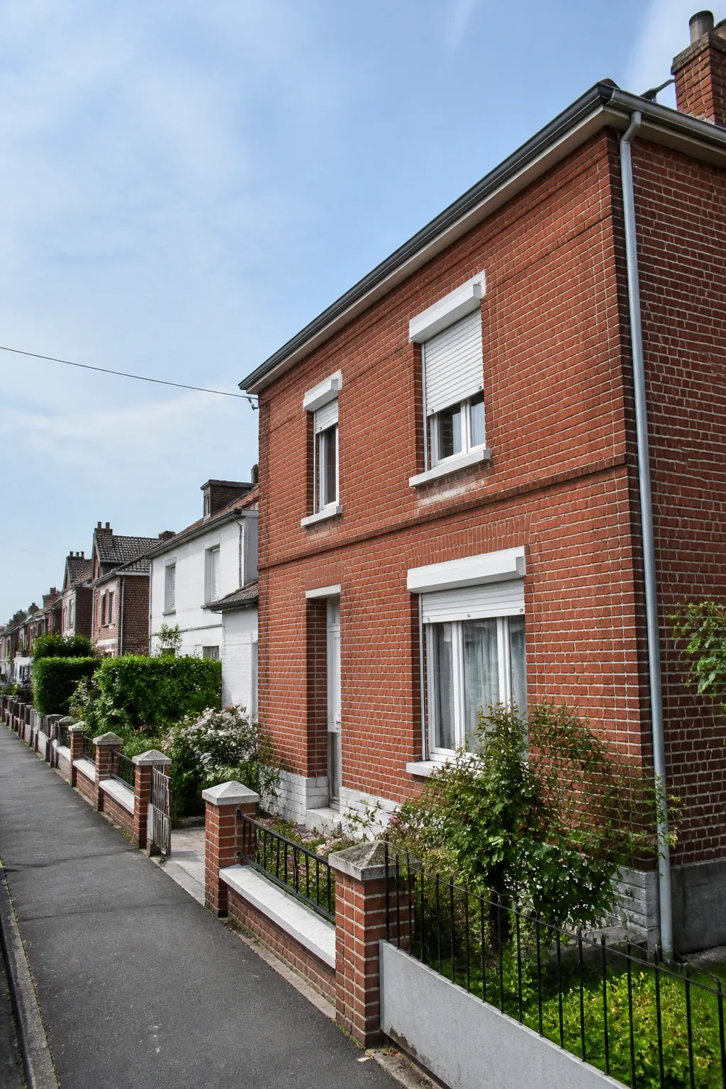 Maison en brique avec jardin dans une rue résidentielle du nord