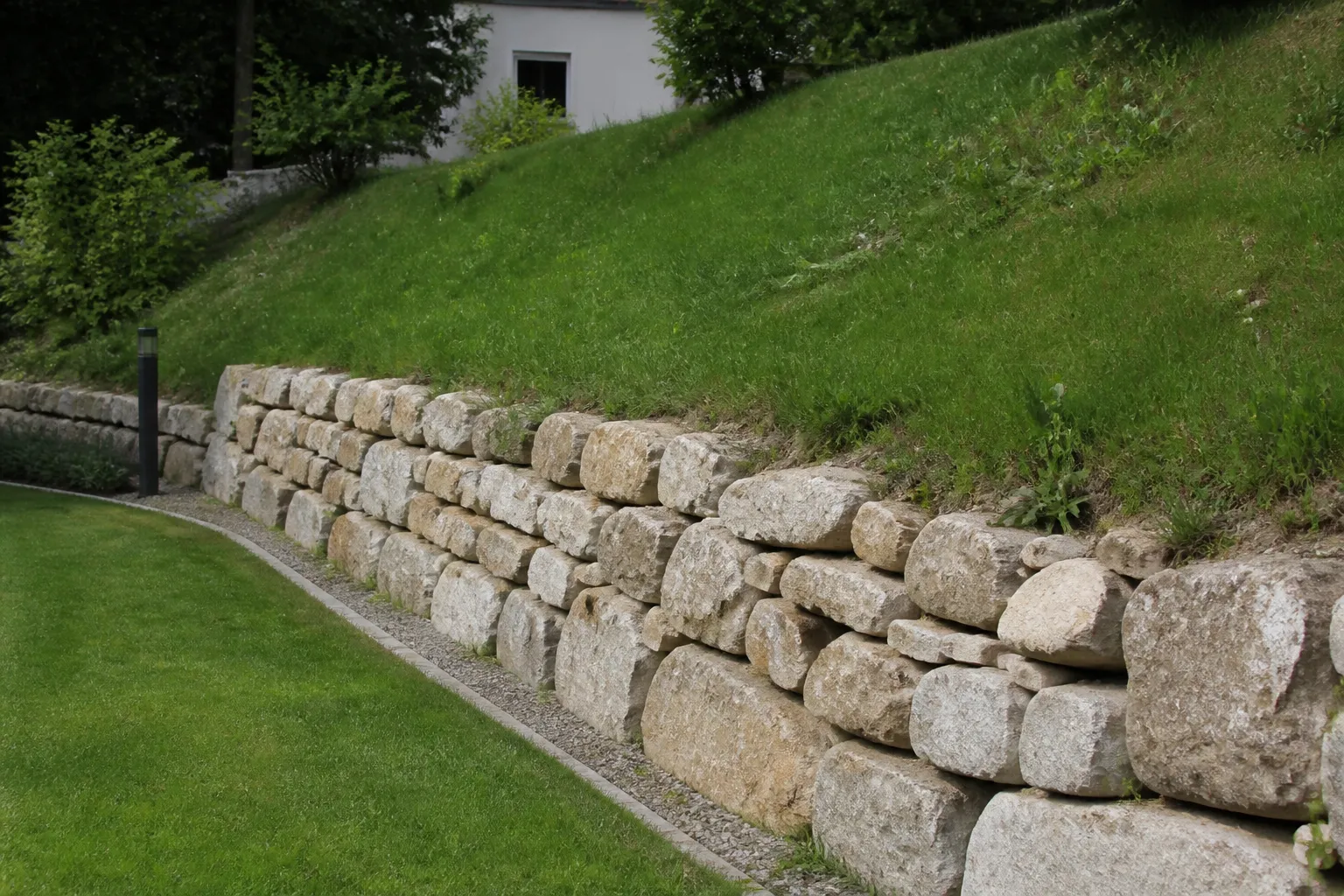 Talus herbeux et mur de soutènement au bord d’un jardin