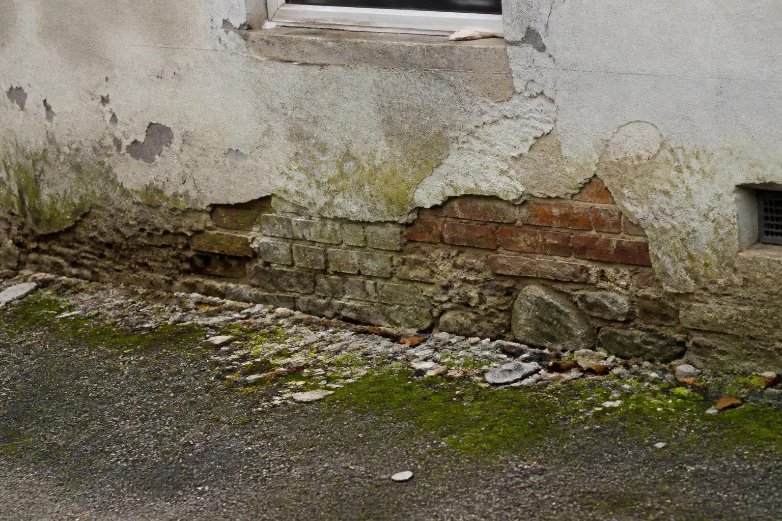 Mur de soubassement humide d’une maison ancienne près de l’eau