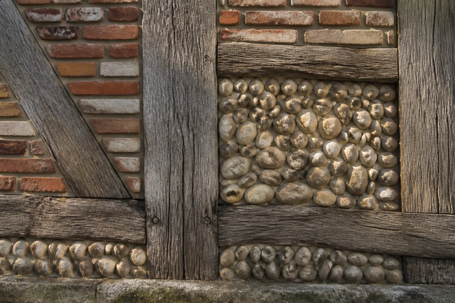 Détail d’un pan de bois avec remplissage de briques et galets