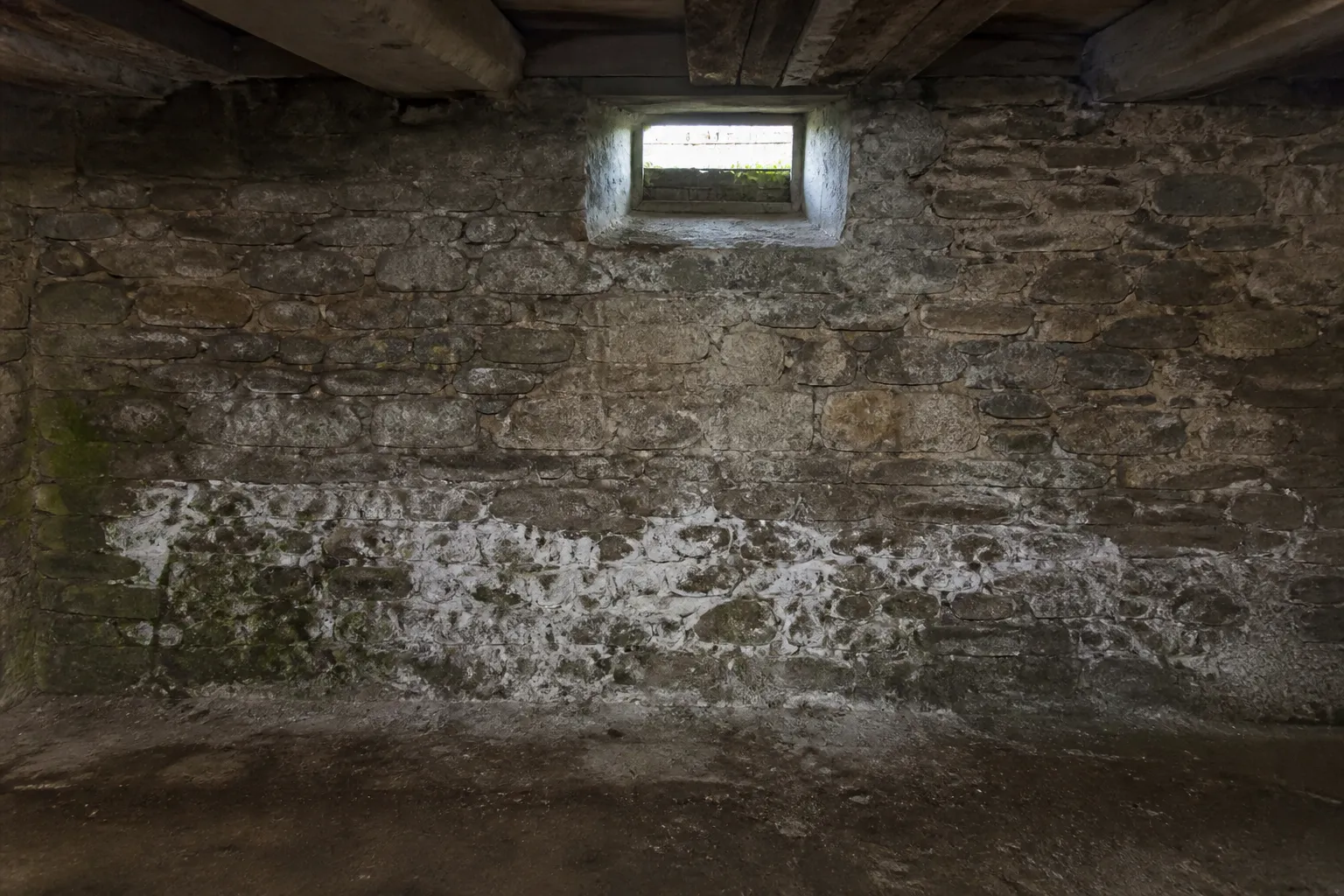 Mur de cave en pierre présentant des traces d’humidité
