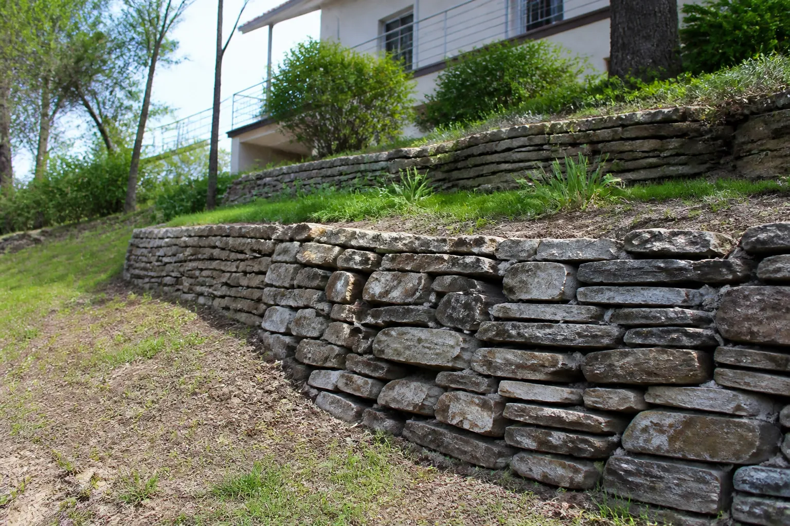 Terrain en pente avec mur de soutènement en pierres sèches