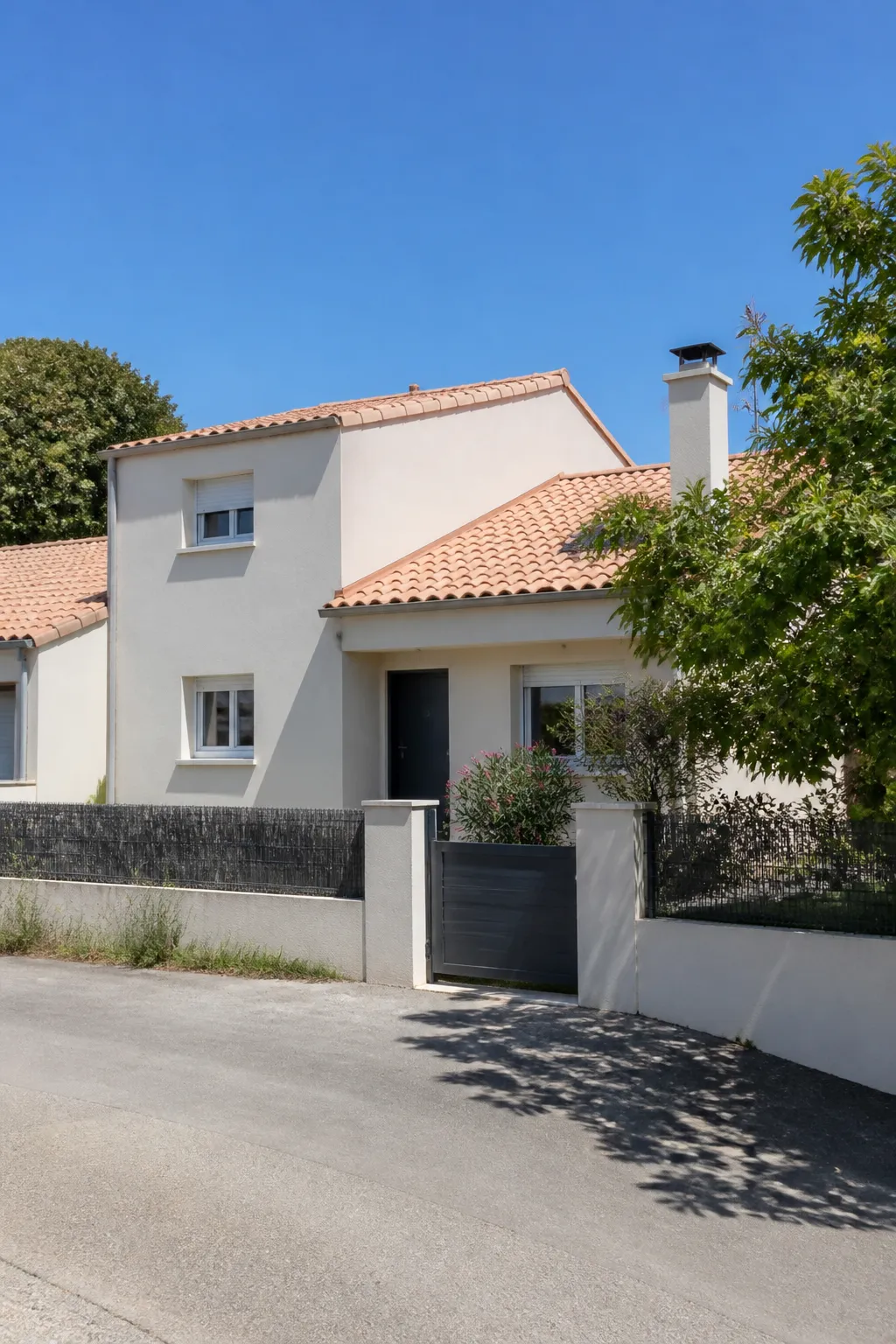 Maison enduite avec toit de tuiles et jardin dans une rue de Challans