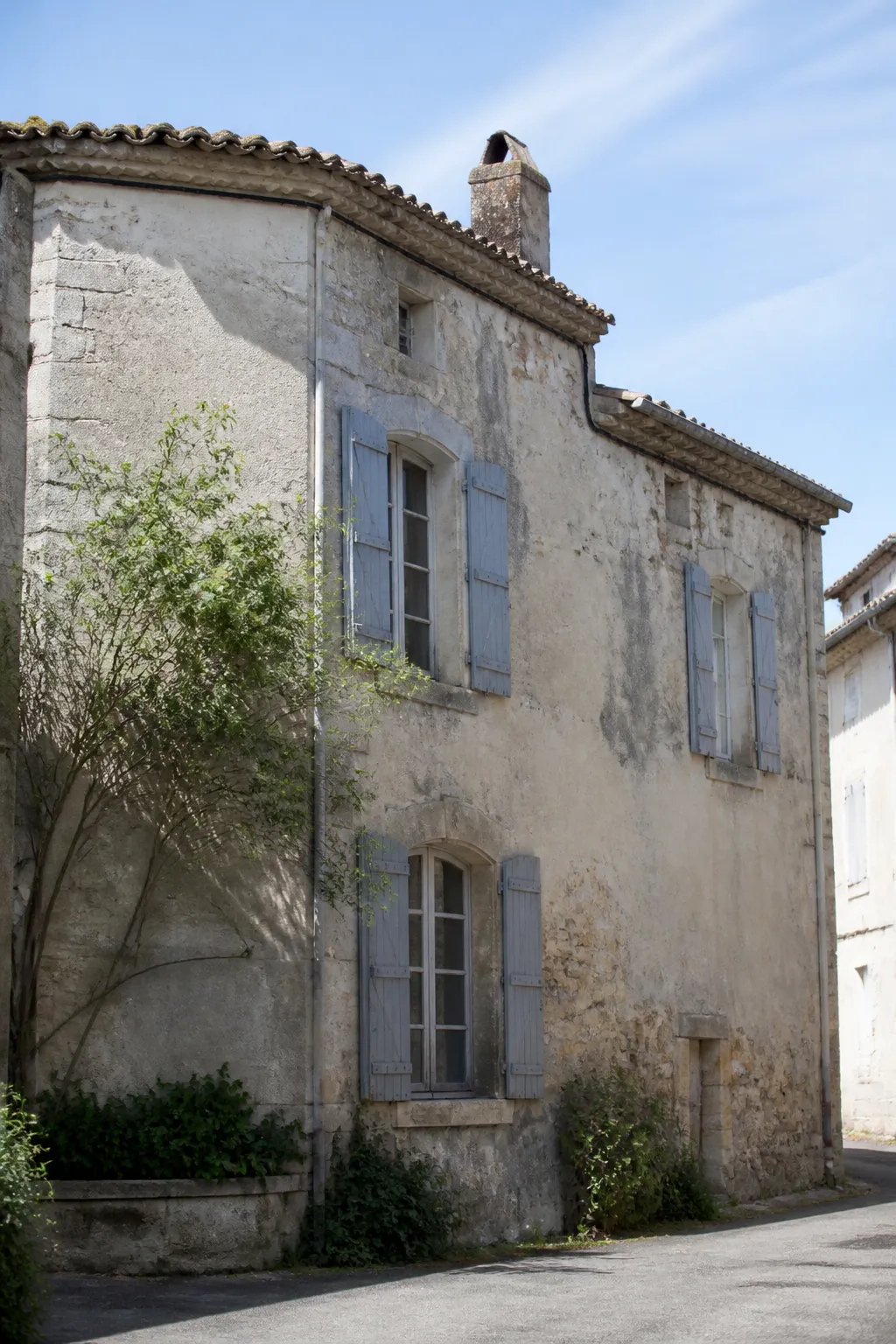 Maison en pierre et enduit avec toit de tuiles dans une petite ville de Vendée