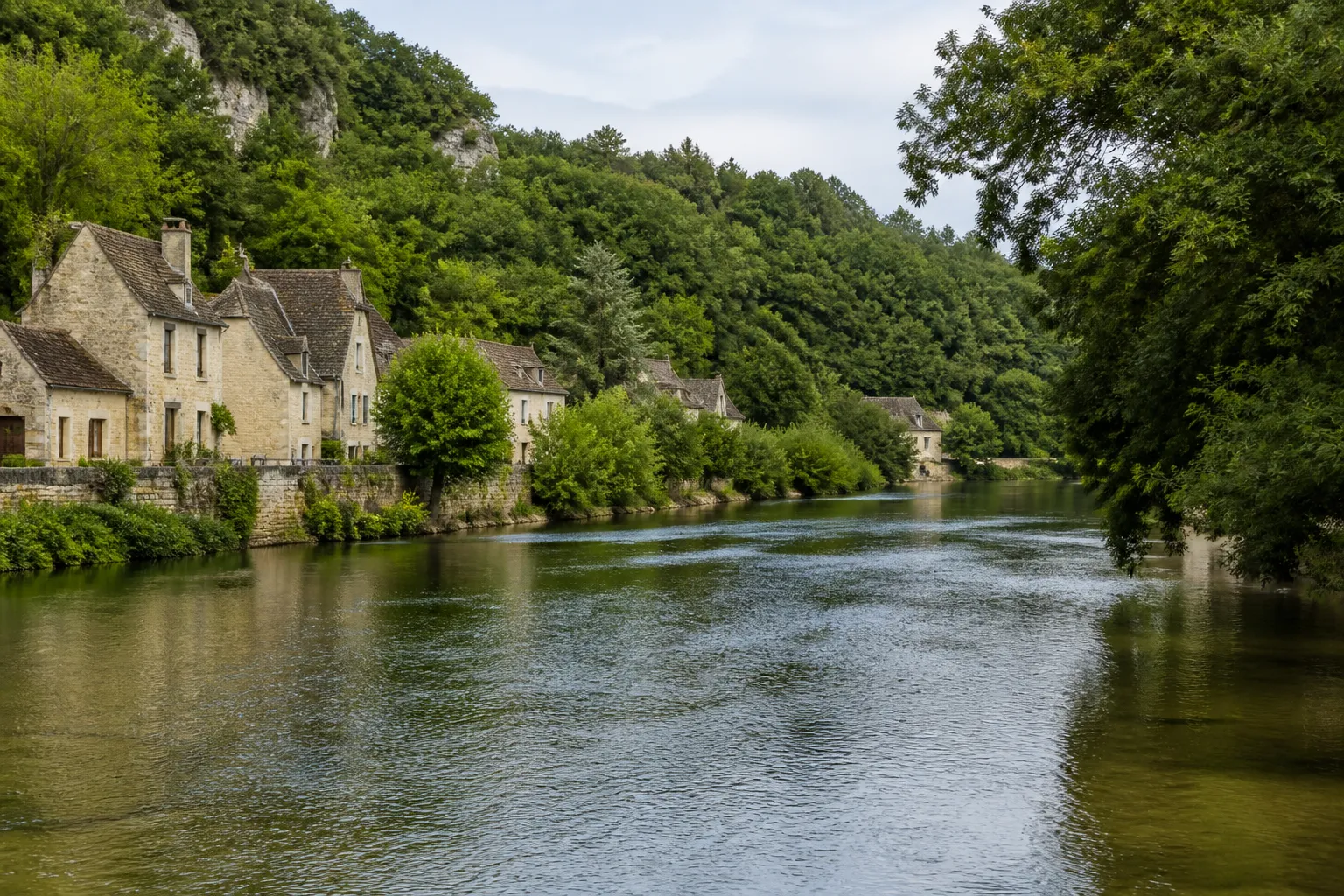 Rivière large bordée de maisons et d’arbres en ville