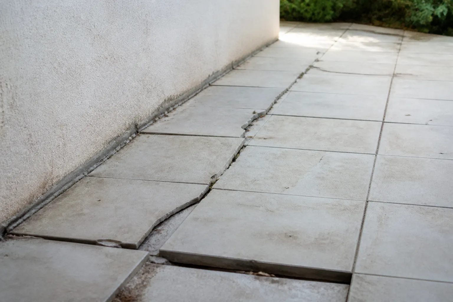 Dallage de terrasse fissuré au pied d’une maison