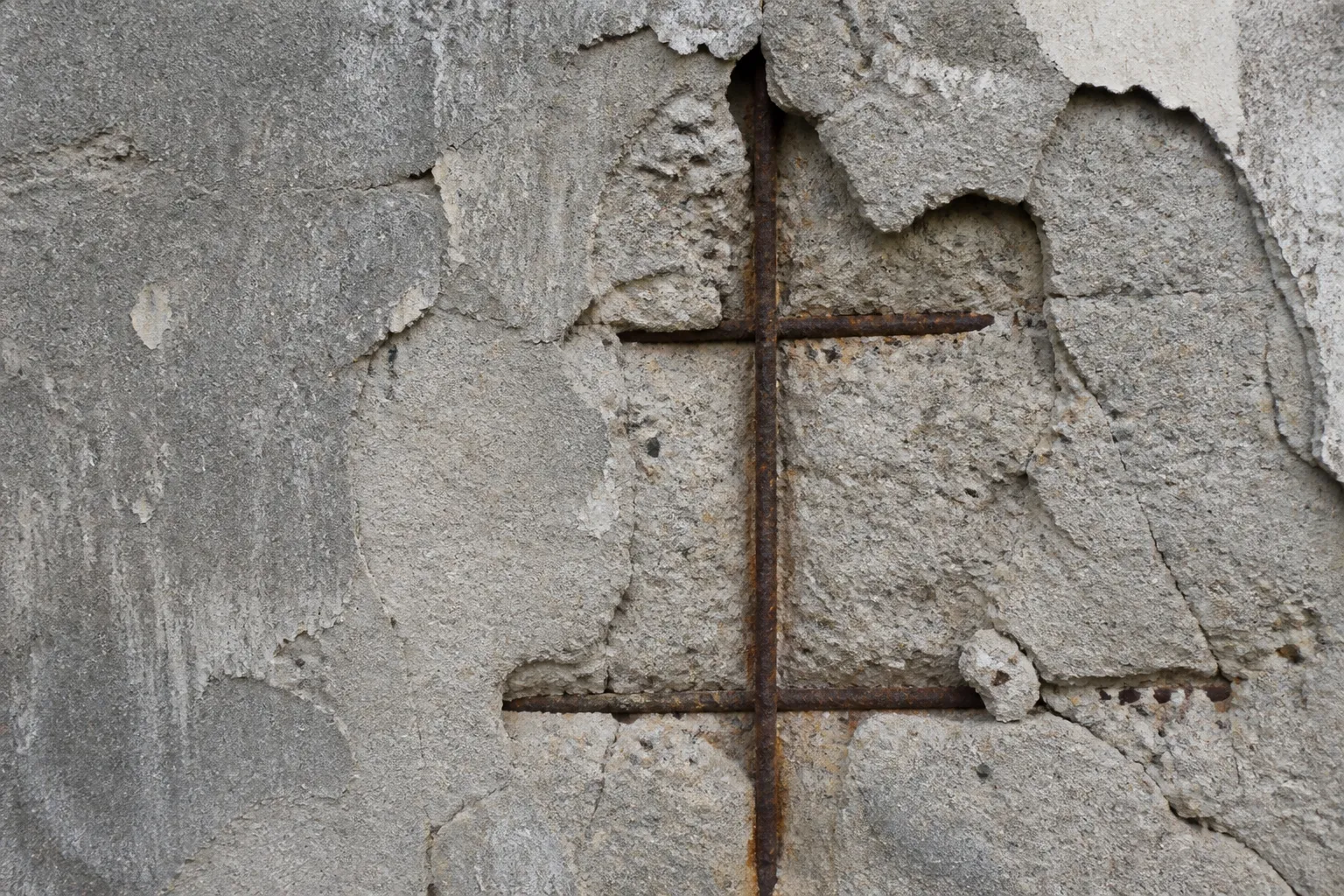 Détail d’une façade en béton avec épaufrure et armature apparente