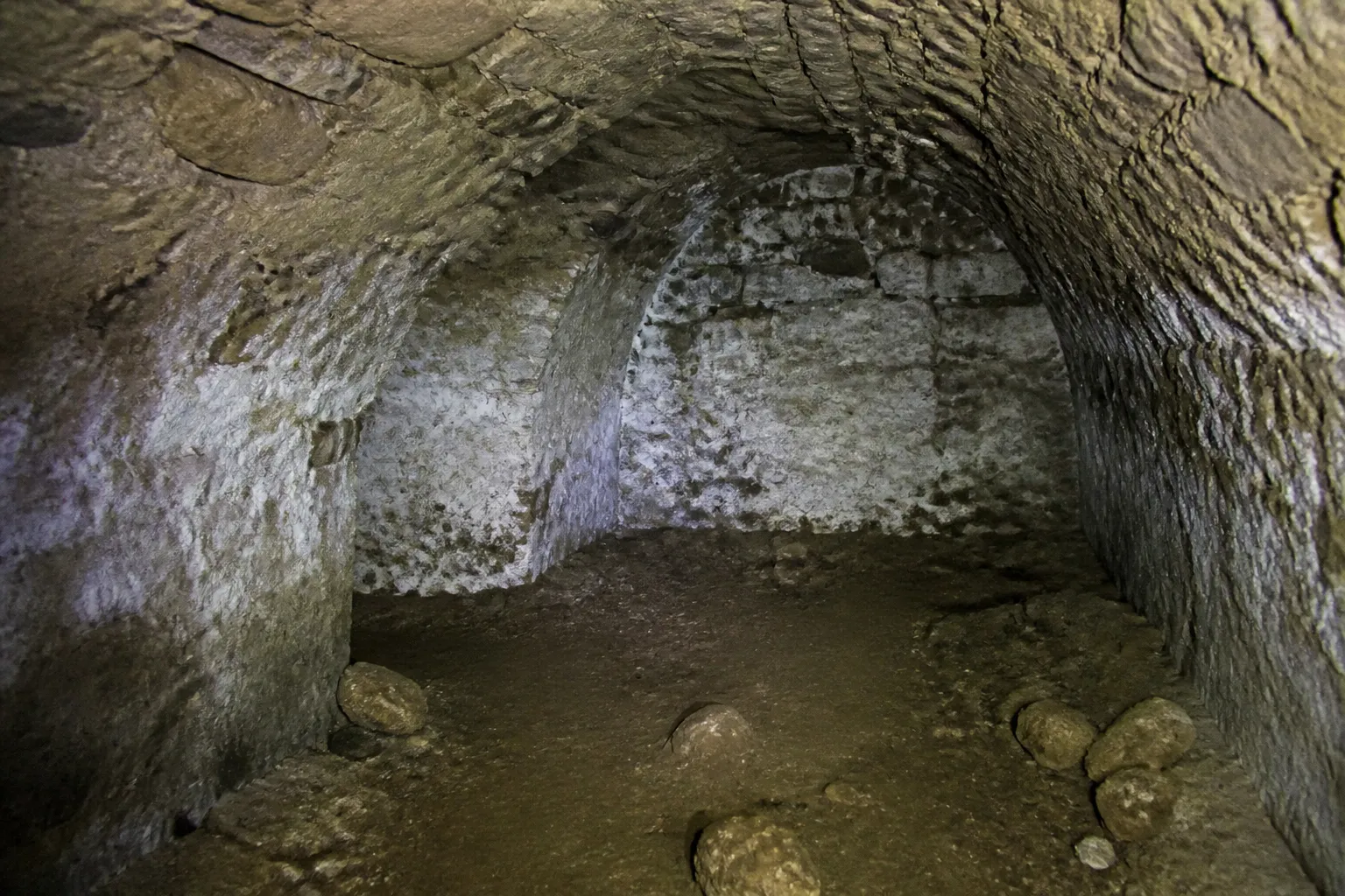 Cave voûtée en pierre inspectée à la lampe lors d’une expertise
