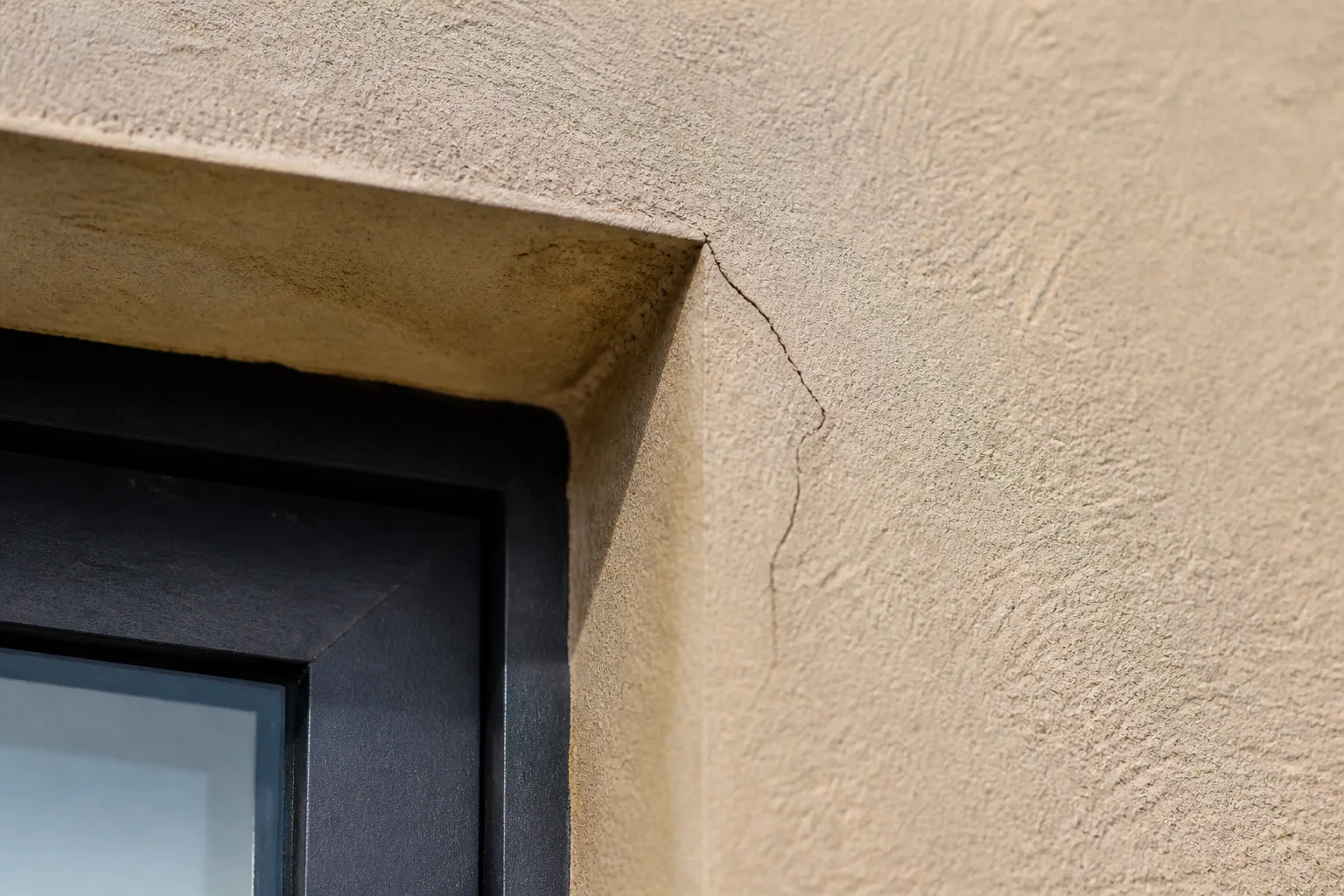Fissure fine sur un linteau de fenêtre observée de près