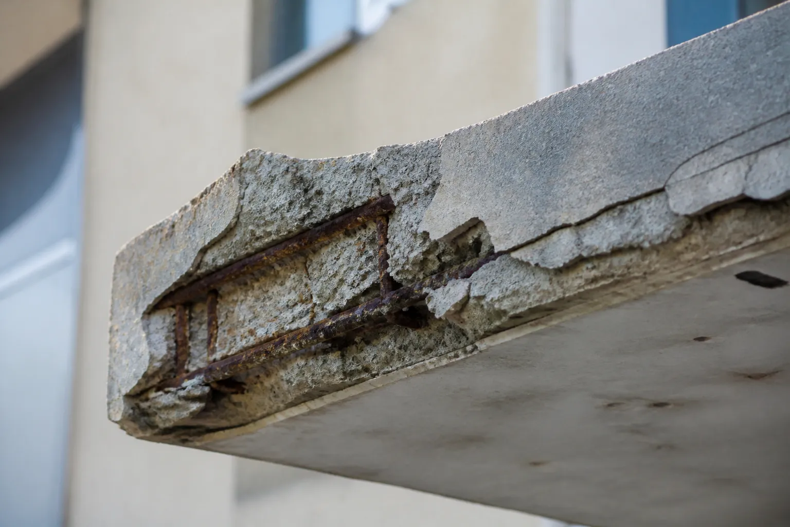 Façade en béton avec éclats observée lors d’une expertise