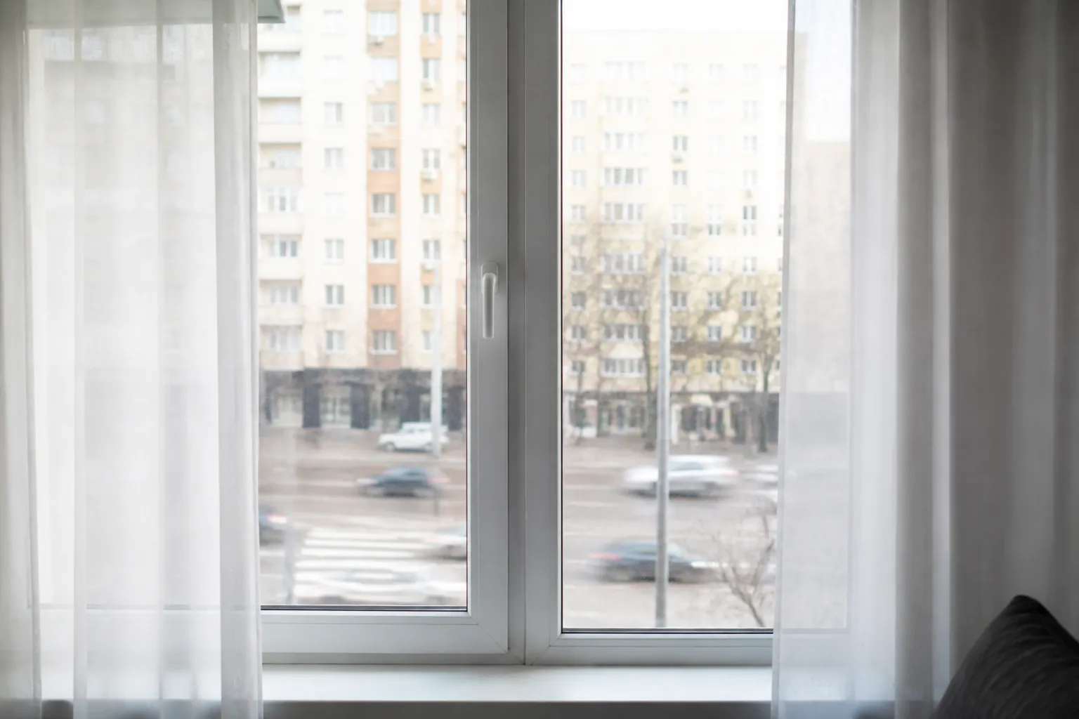 Fenêtre d’appartement donnant sur une rue circulée