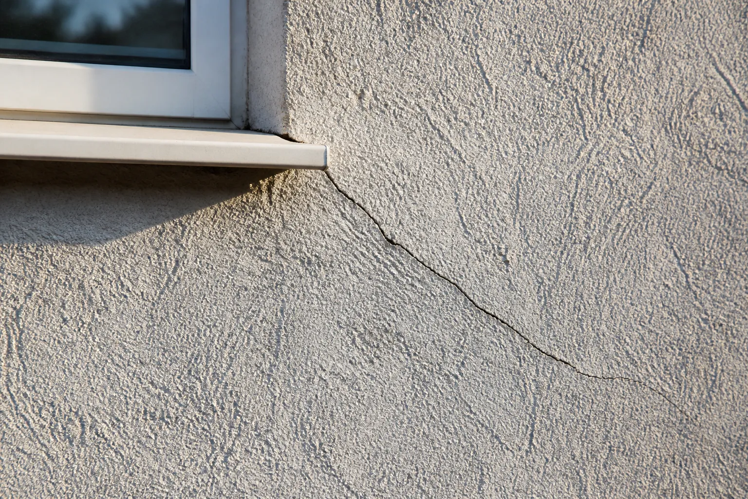 Fissure oblique au-dessus d’une fenêtre de maison