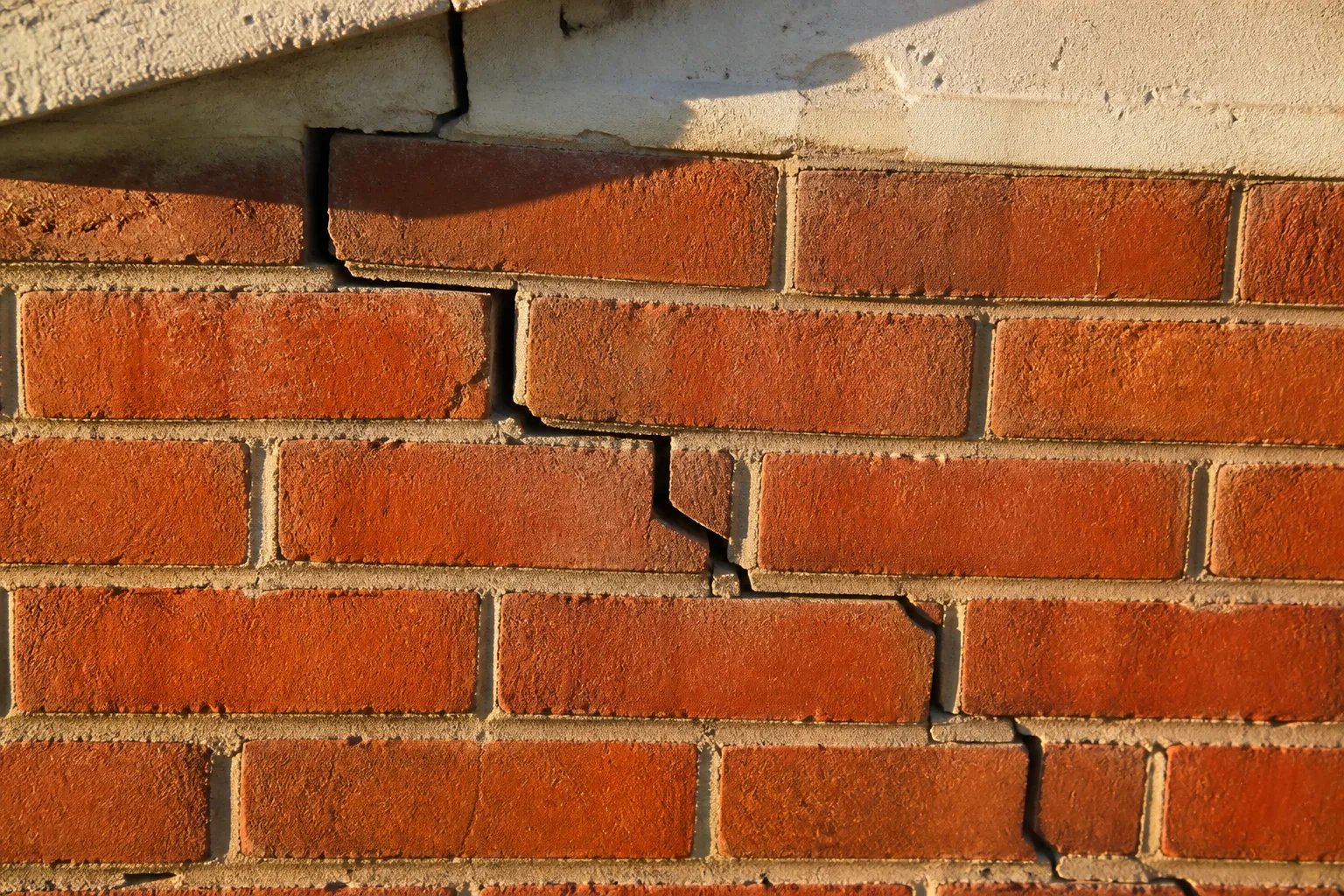 Fissure en escalier sur un mur de pavillon en briques