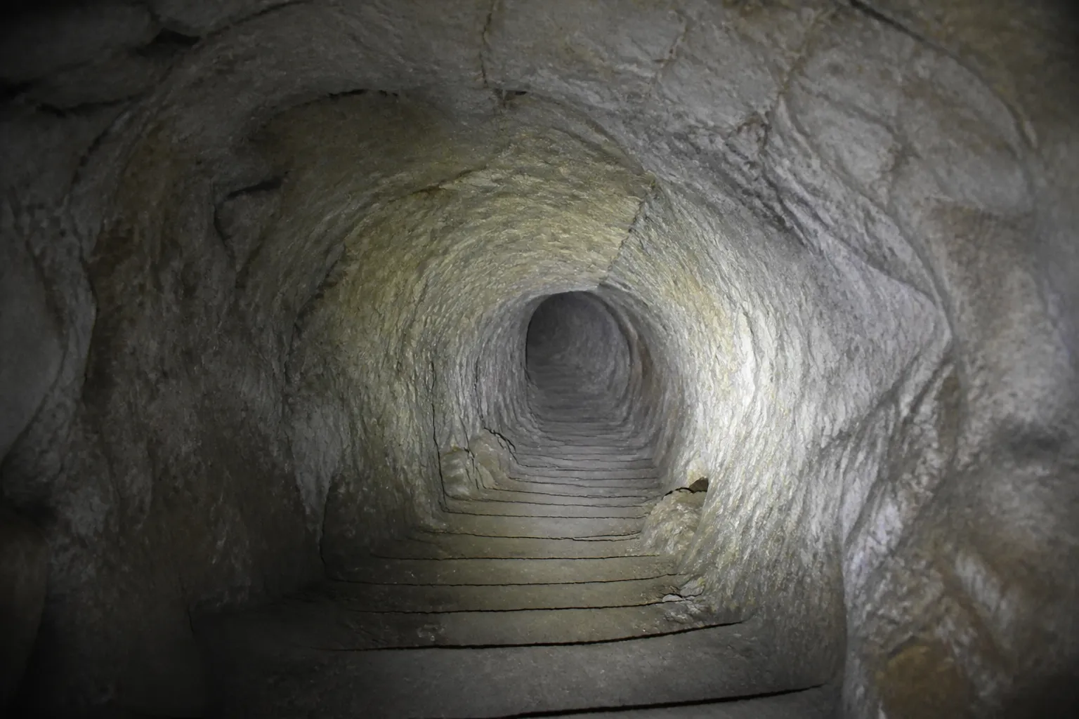 Cave ancienne voûtée taillée dans le calcaire avec escalier