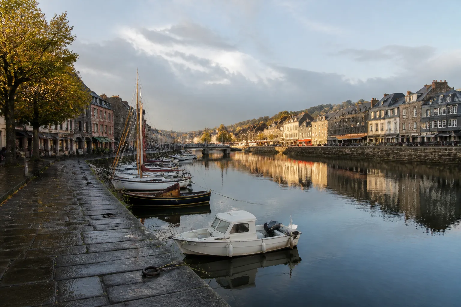 Fleuve calme bordé de quais en pierre et de maisons anciennes