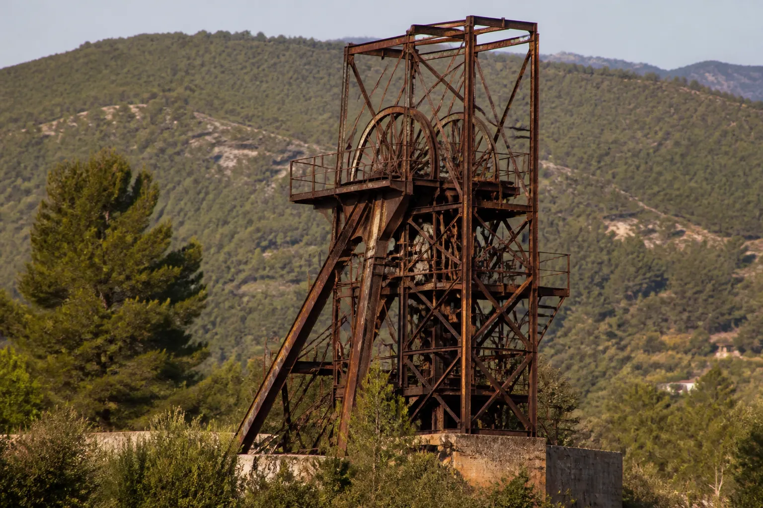 Ancien chevalement minier dans un paysage de collines boisées