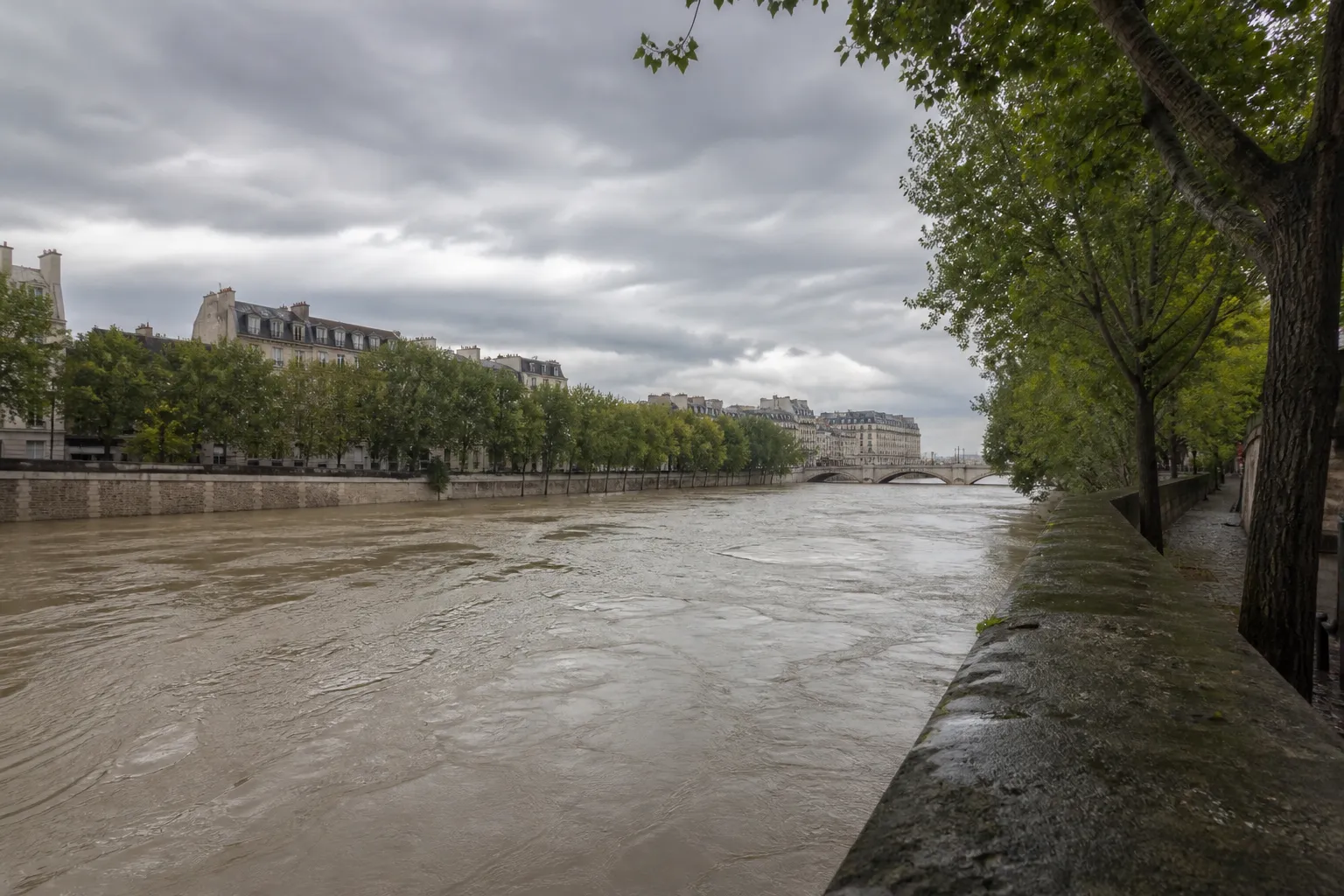 Rivière en ville bordée de quais en pierre en période de hautes eaux