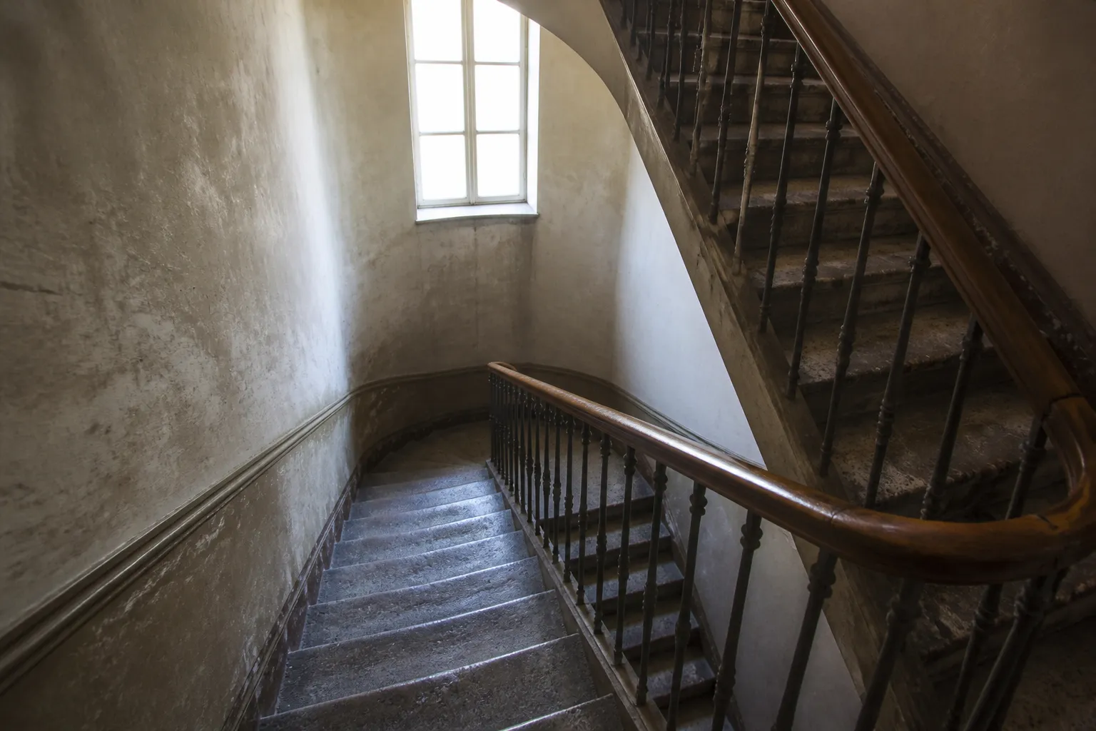 Cage d’escalier ancienne d’un immeuble en copropriété avec marches en pierre