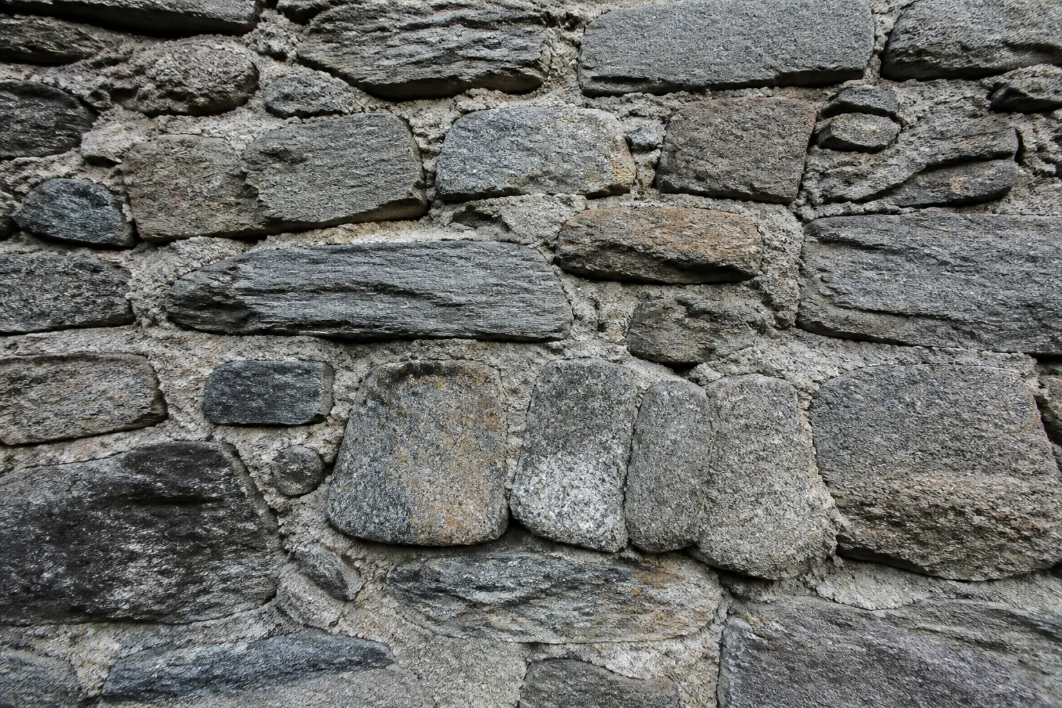 Mur ancien en moellons de granite et de schiste avec joints à reprendre