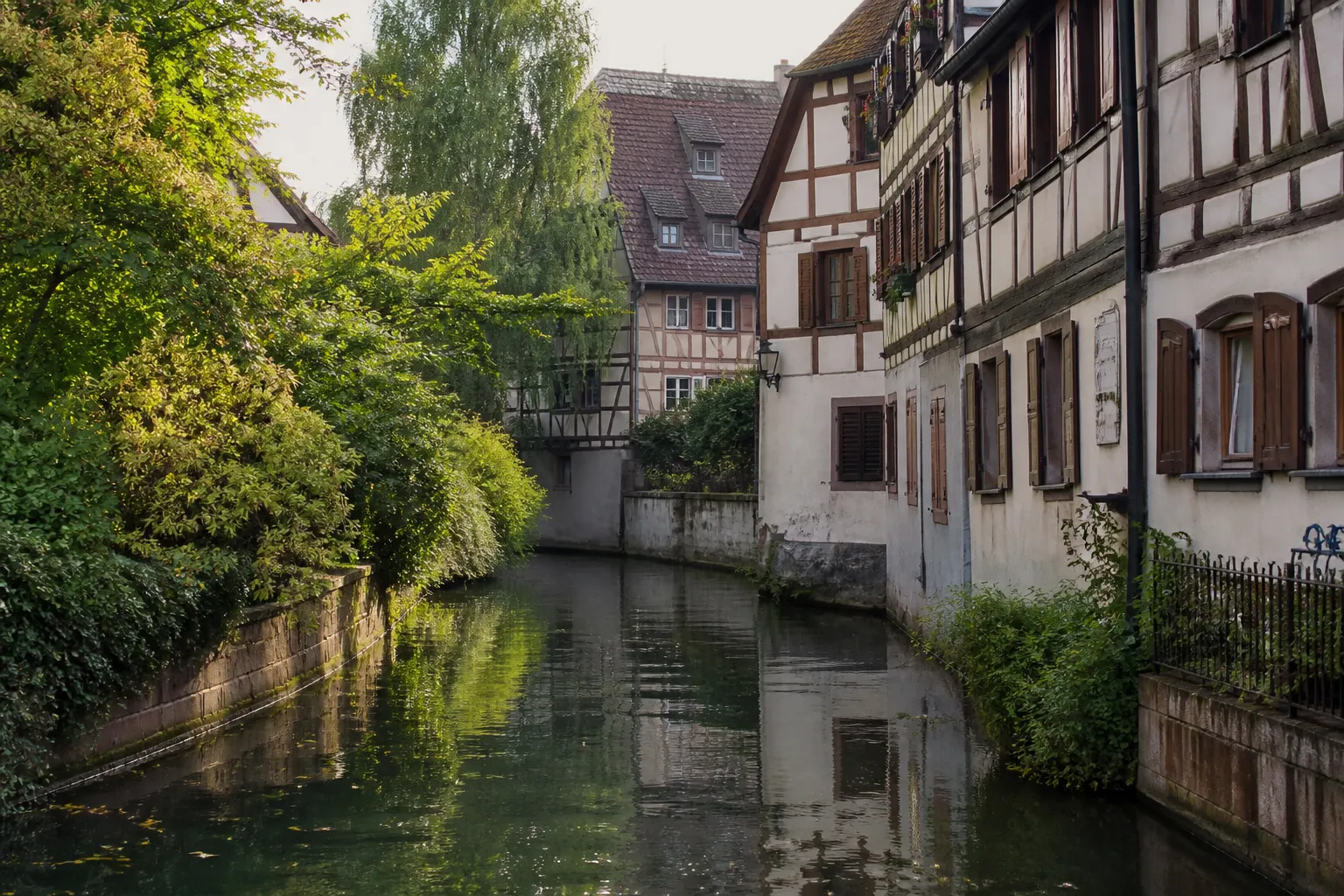 Rivière bordée de maisons anciennes dans un centre-ville alsacien