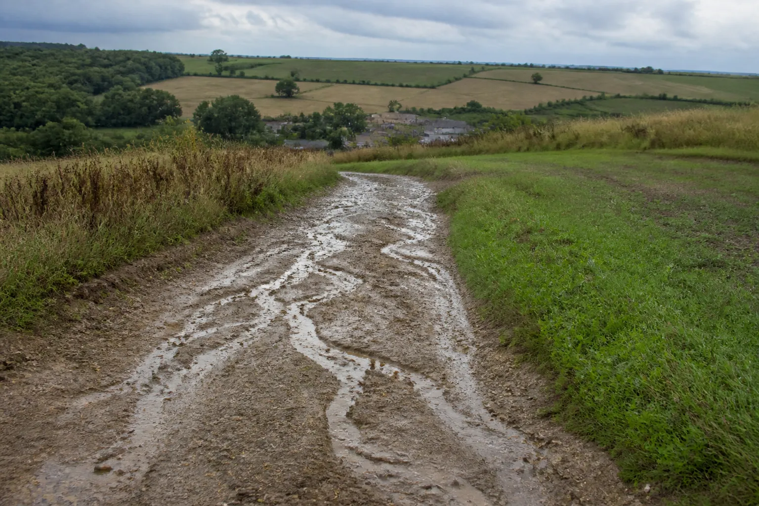 Chemin agricole en pente après un orage avec traces de ruissellement