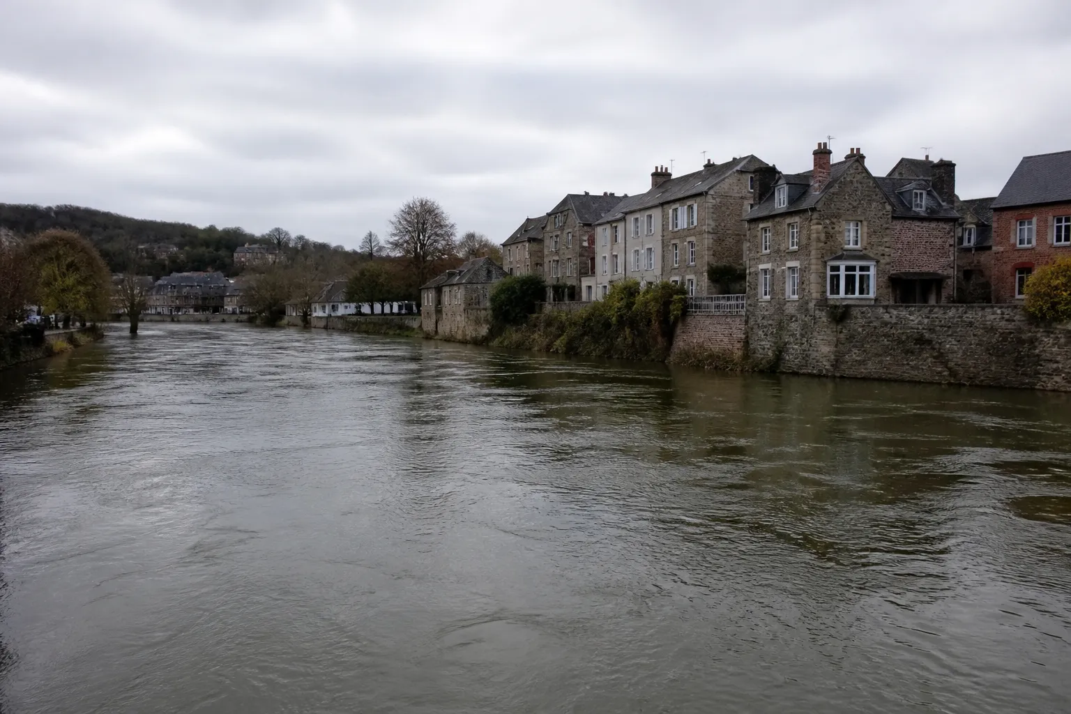 Rivière en crue lente longeant des maisons de bourg