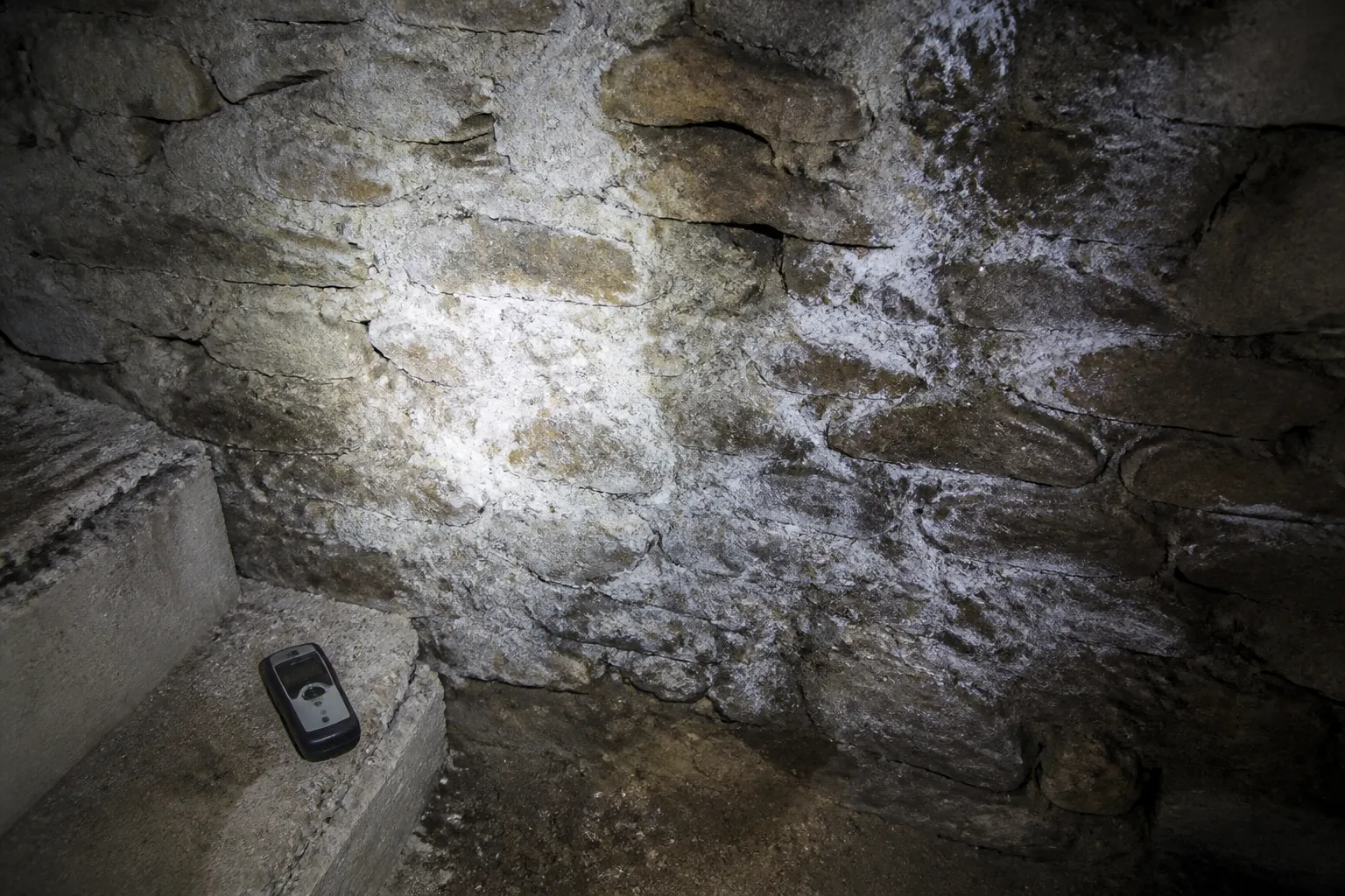 Mur de sous-sol avec traces d’humidité observé à la lampe