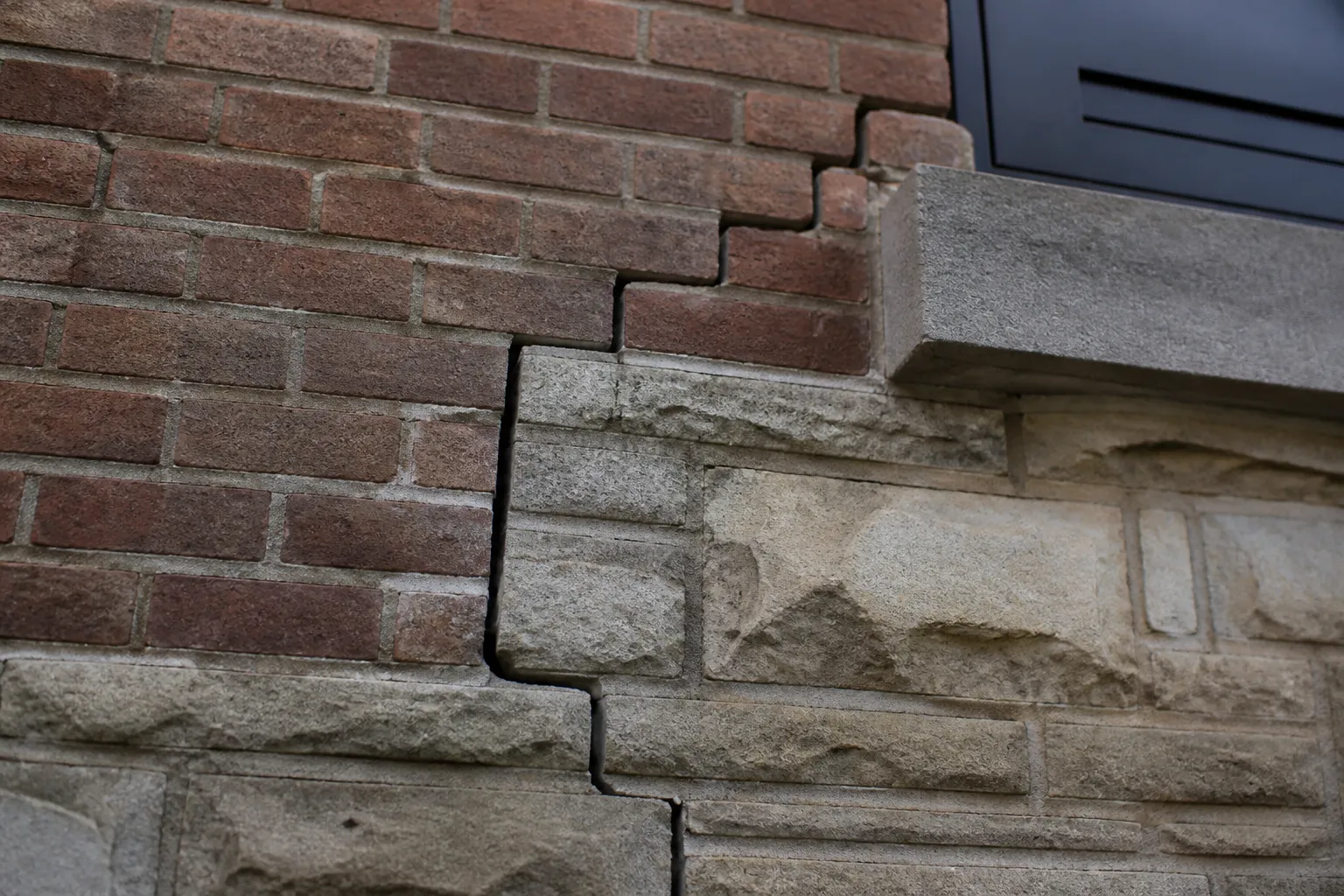 Fissure en escalier sur une façade en briques