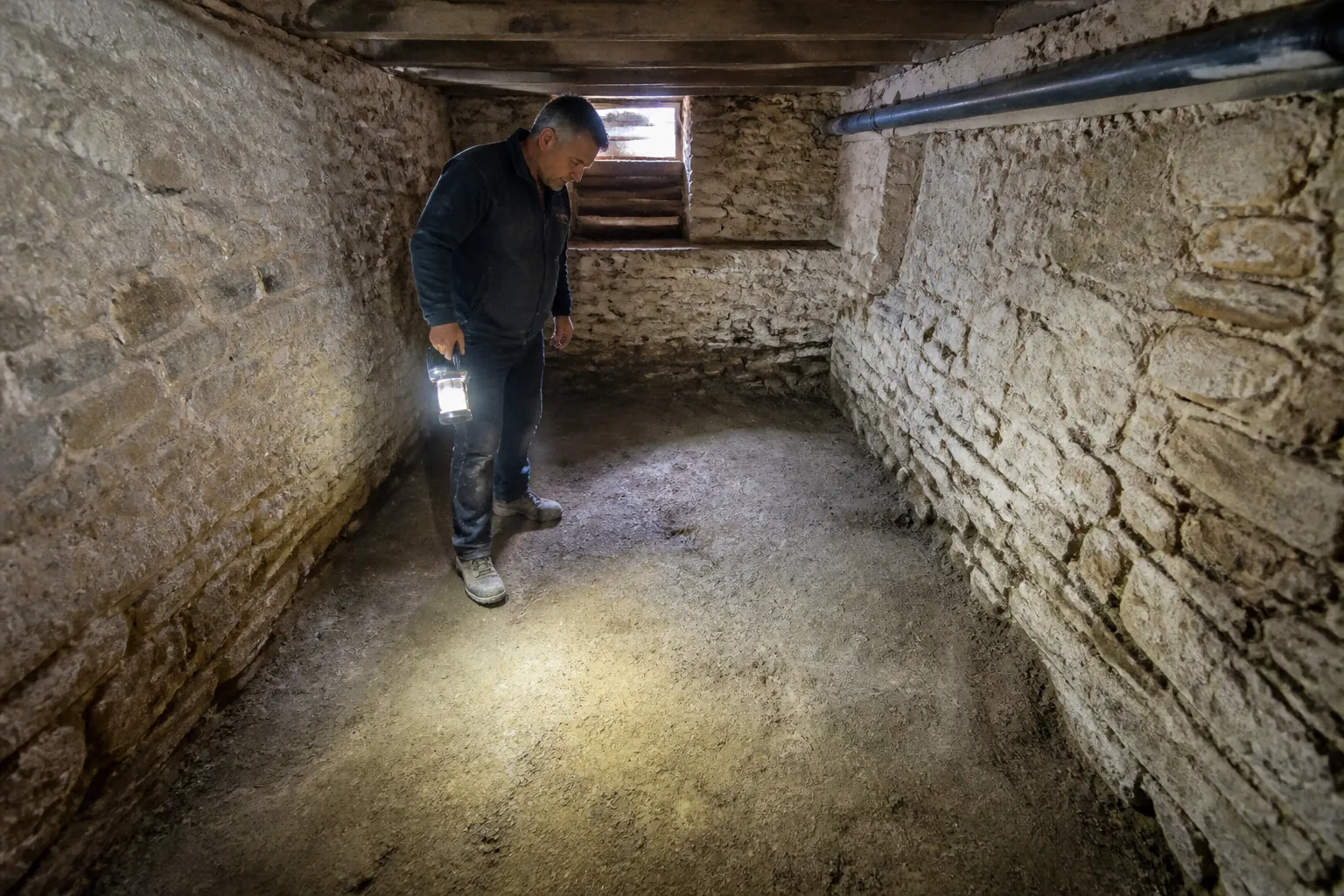 Sol de cave en terre battue observé avec une lampe