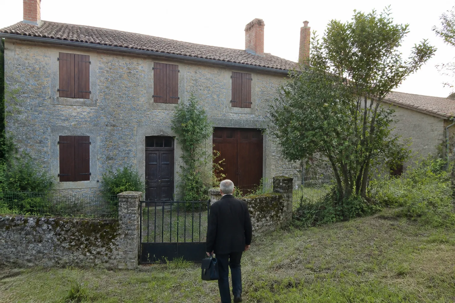 Maison ancienne volets fermés avant une visite