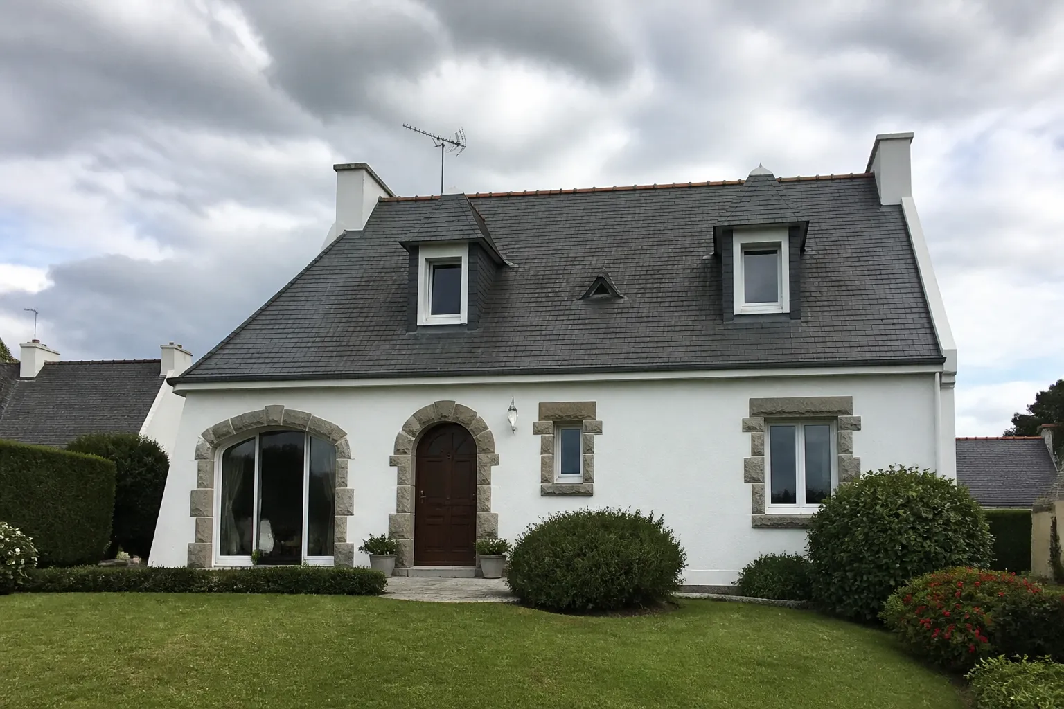Maison néo-bretonne aux murs blancs et toiture d’ardoise