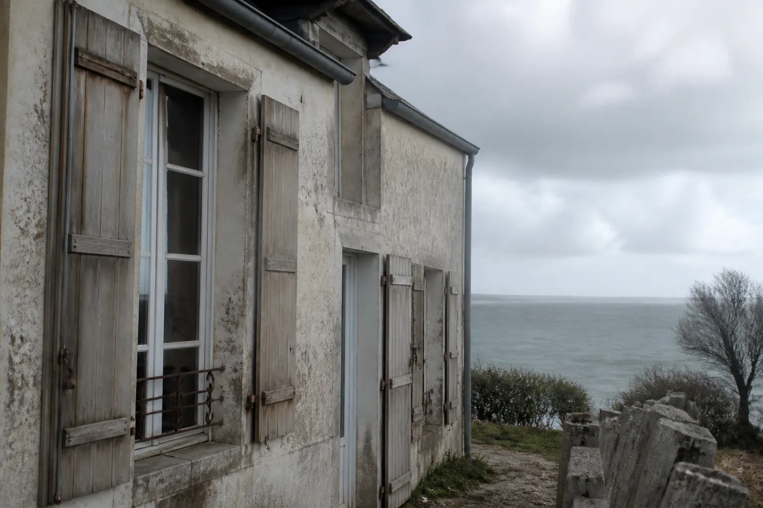 Façade de maison littorale exposée au vent et aux embruns