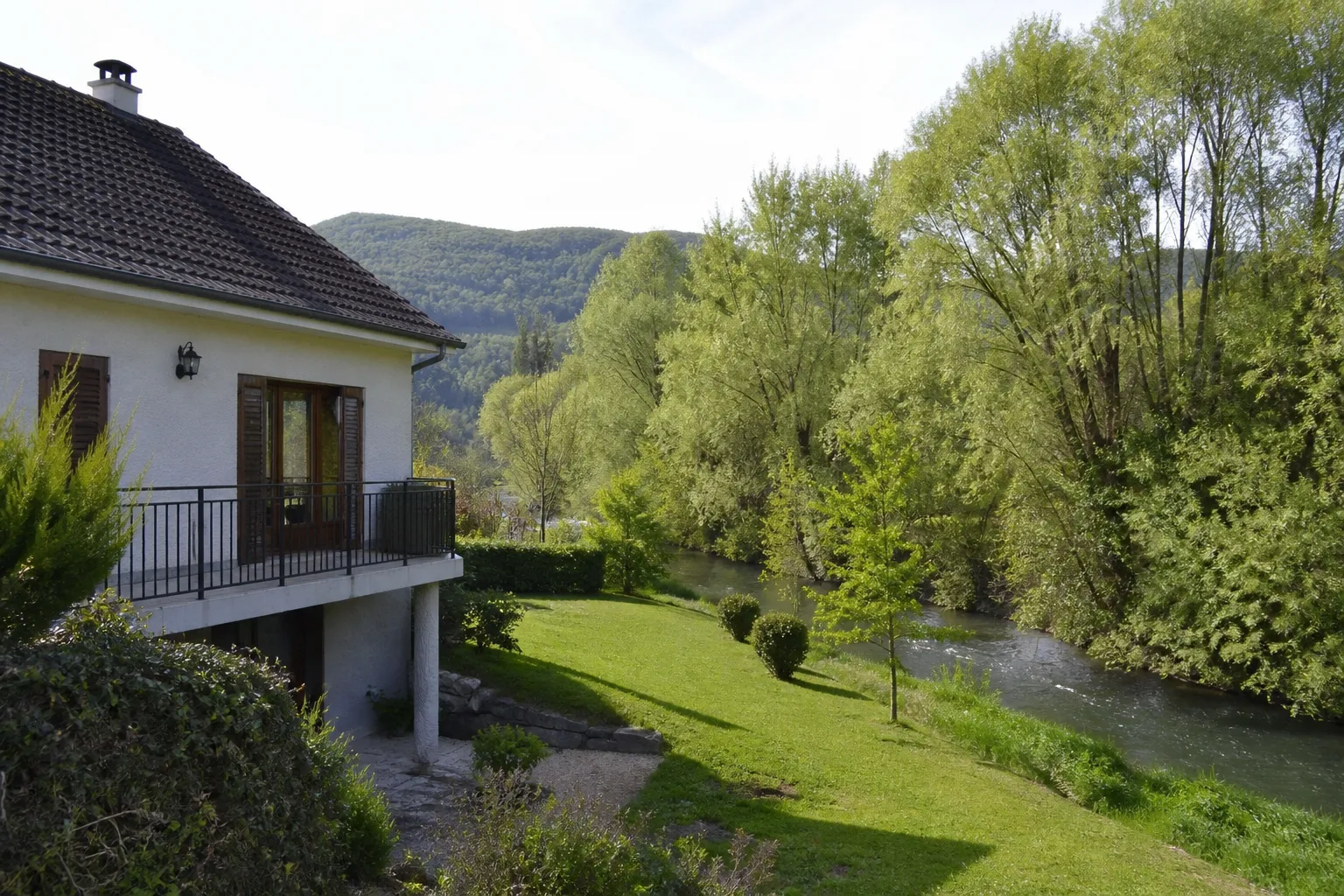Pavillon proche d’une rivière en Haute-Loire, vue du jardin vers le cours d’eau