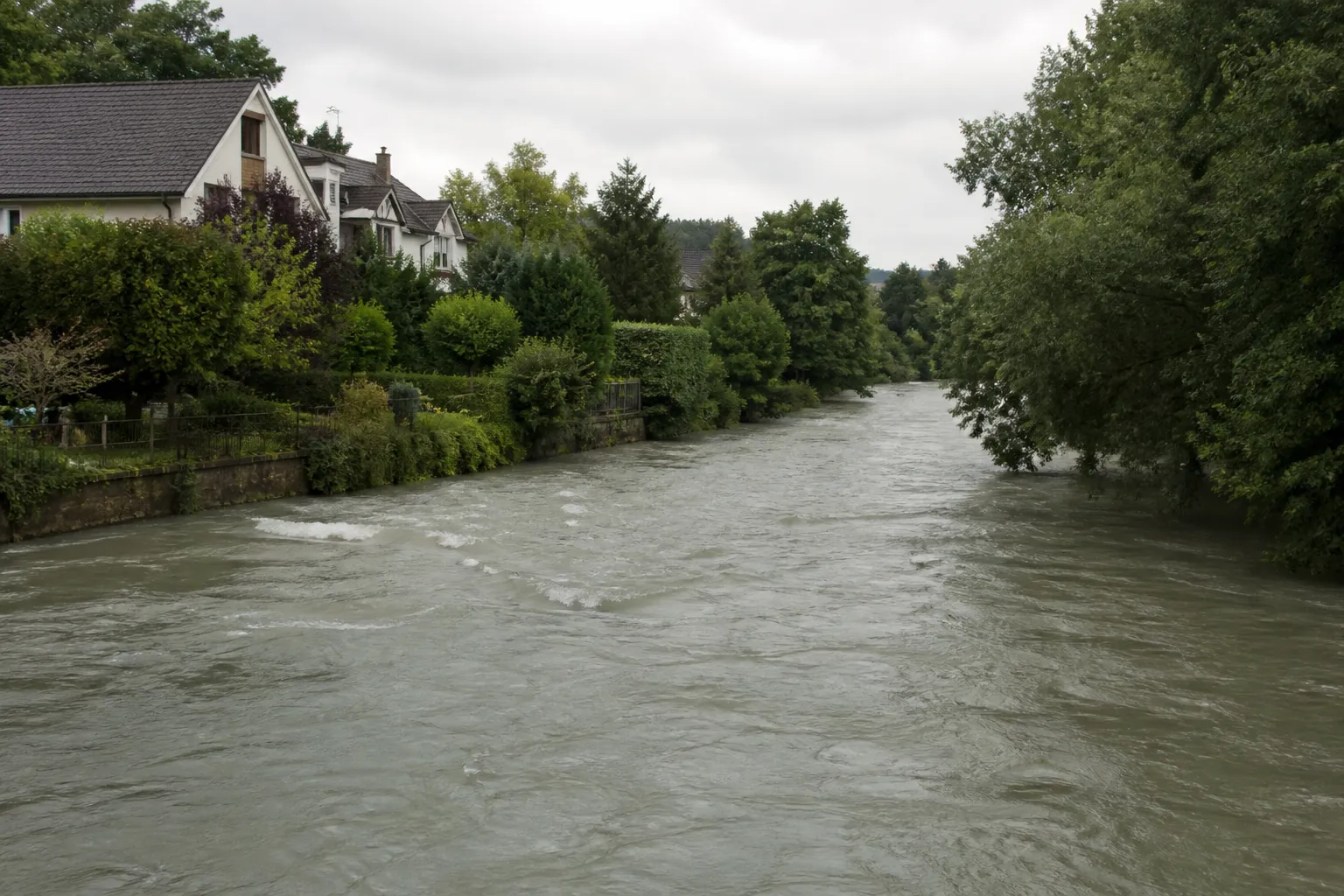 Rivière bordée de maisons et de jardins en période de hautes eaux