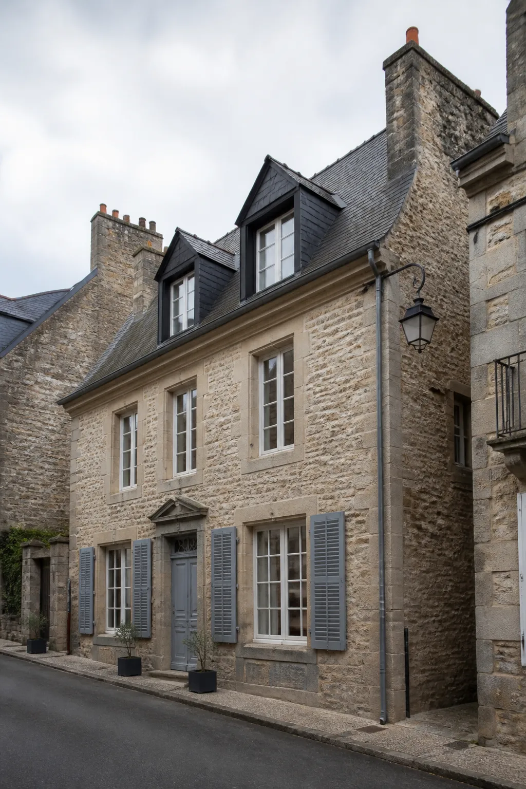 Maison ancienne en pierre avec toiture en ardoise dans une ville de l’ouest