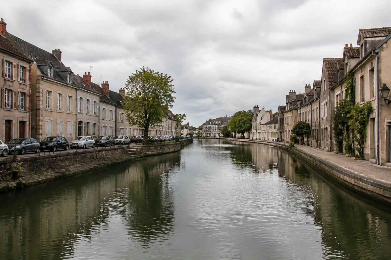 Rivière calme bordée de quais et de maisons