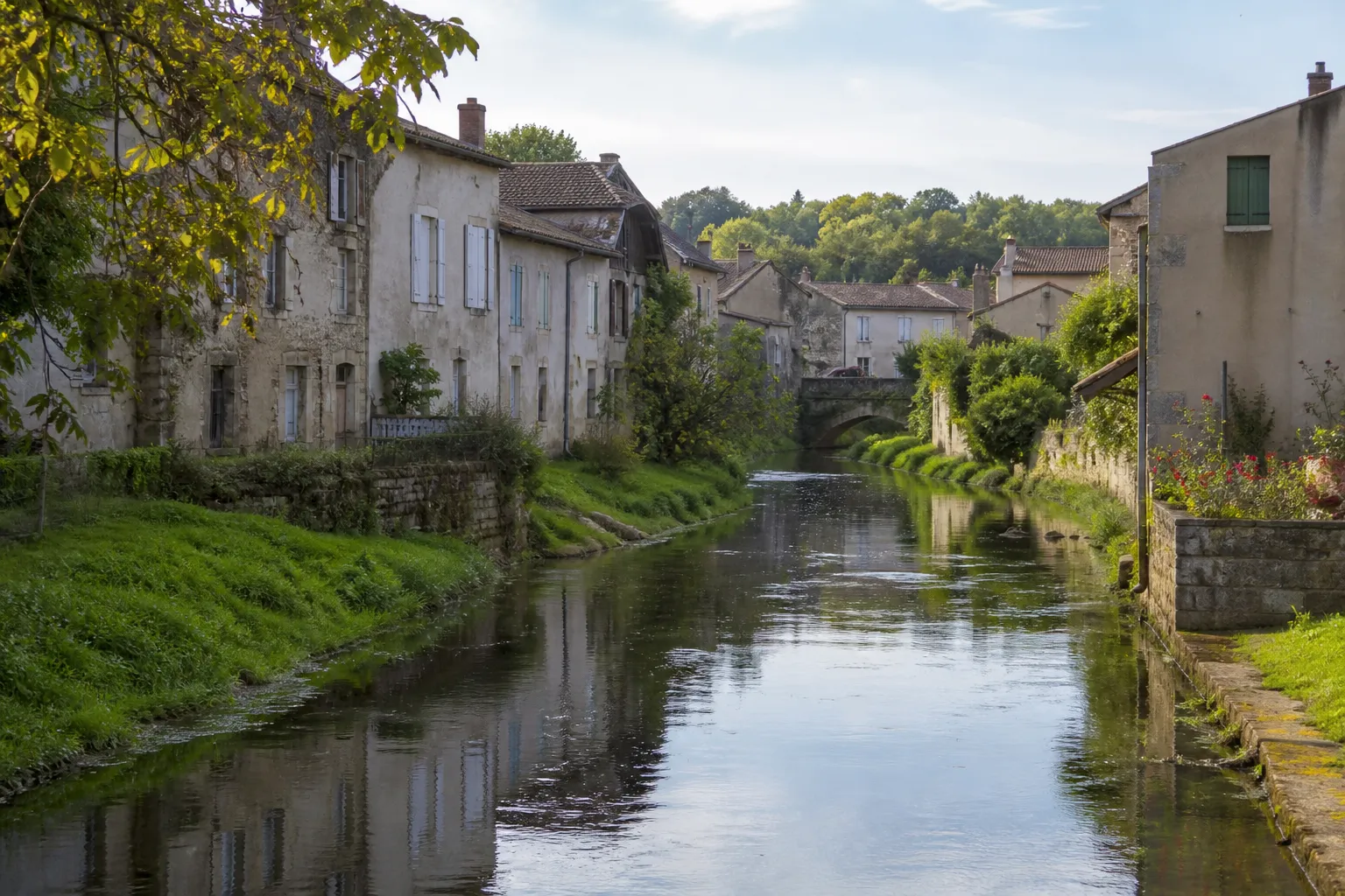 Rivière bordée de maisons et de jardins en Meuse