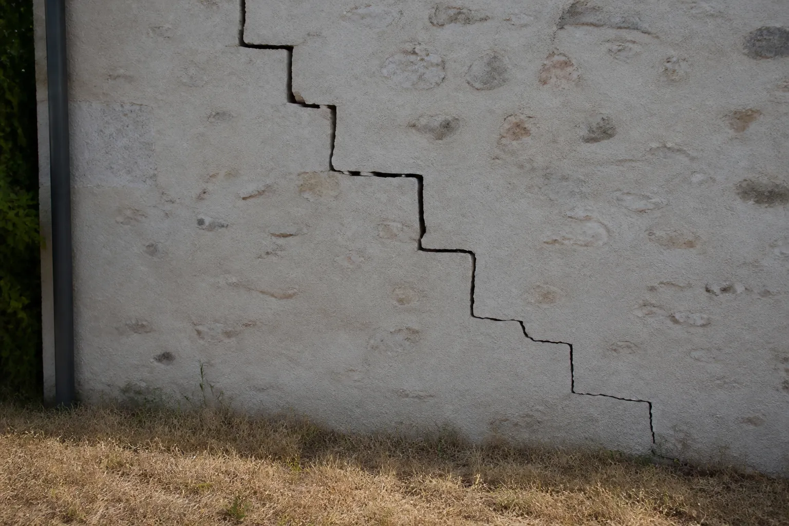 Fissure en escalier sur un mur de maison après un été sec
