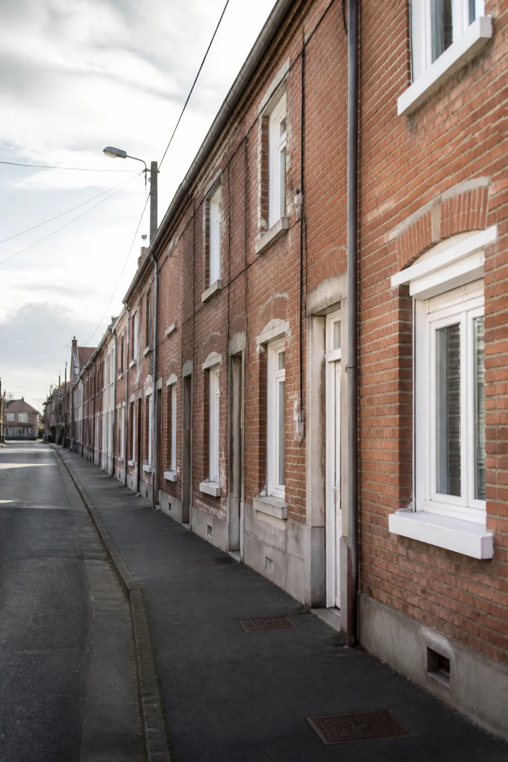 Façade de maisons mitoyennes en brique rouge dans une rue du Nord