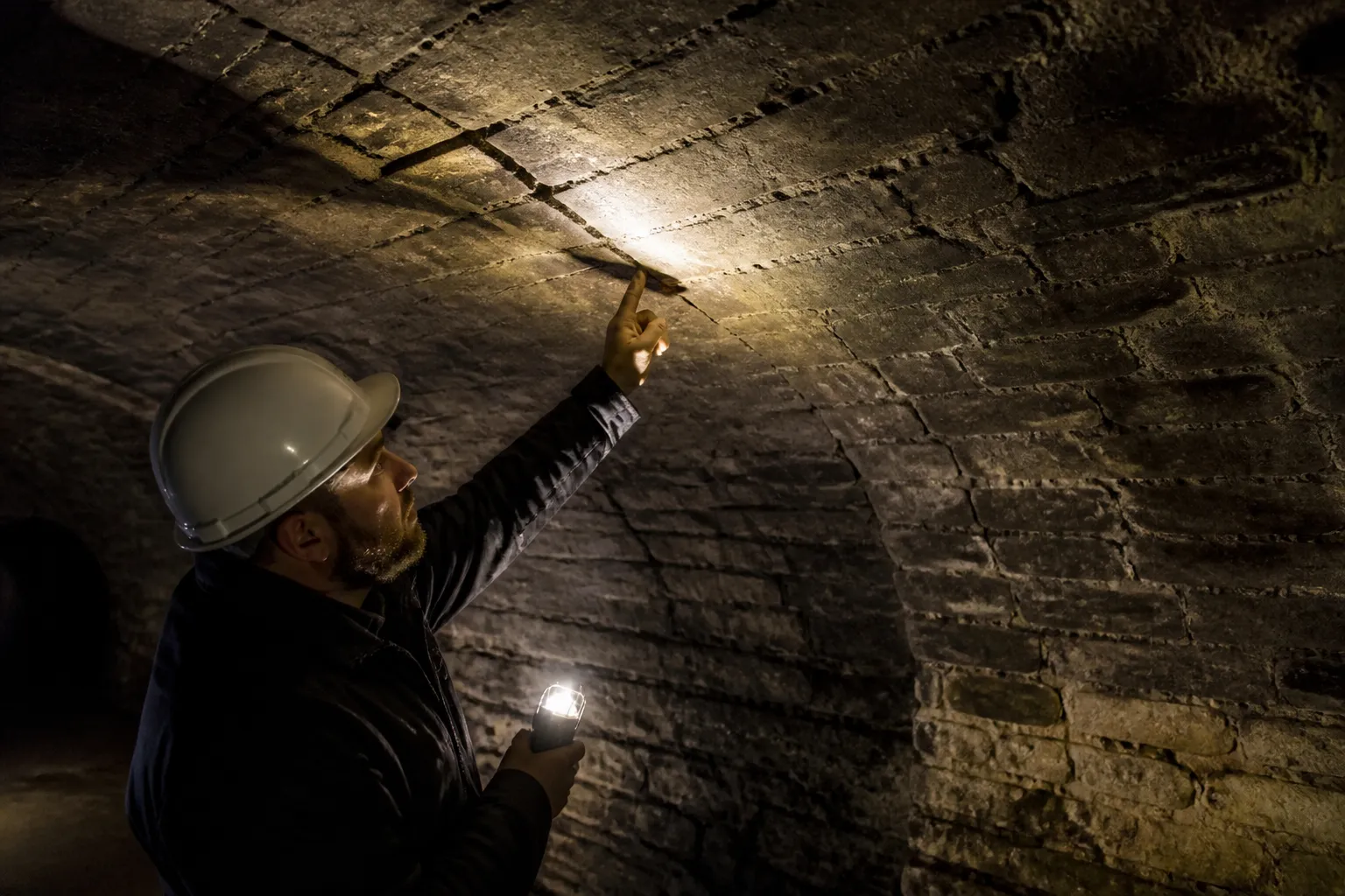 Cave voûtée en pierre examinée à la lampe lors d’une expertise avant achat