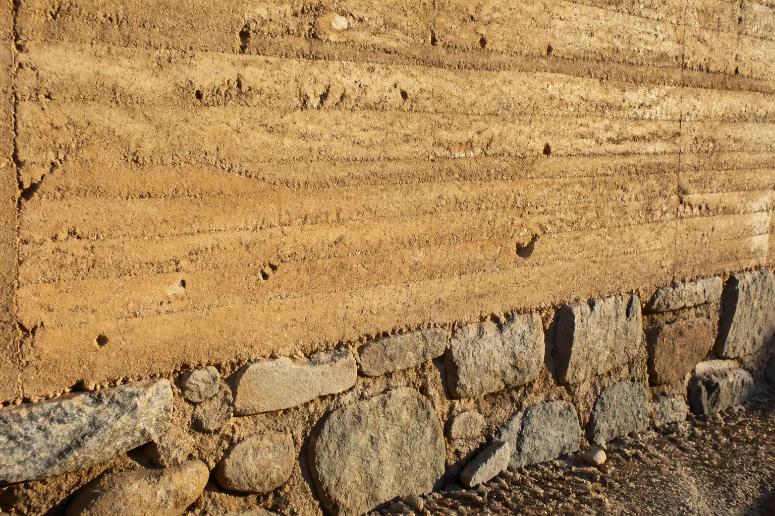 Mur en pisé avec soubassement en pierre